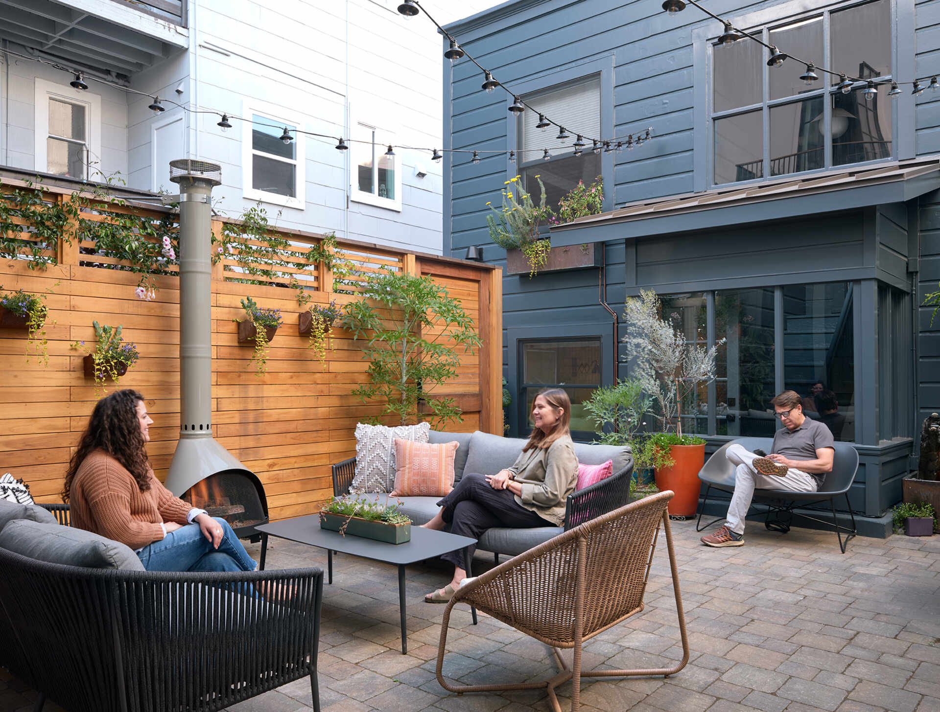 A private San Francisco courtyard links the main house and ADU, with steel-paned windows and doors opening the kitchen, dining room and primary bedroom onto the outdoor space.