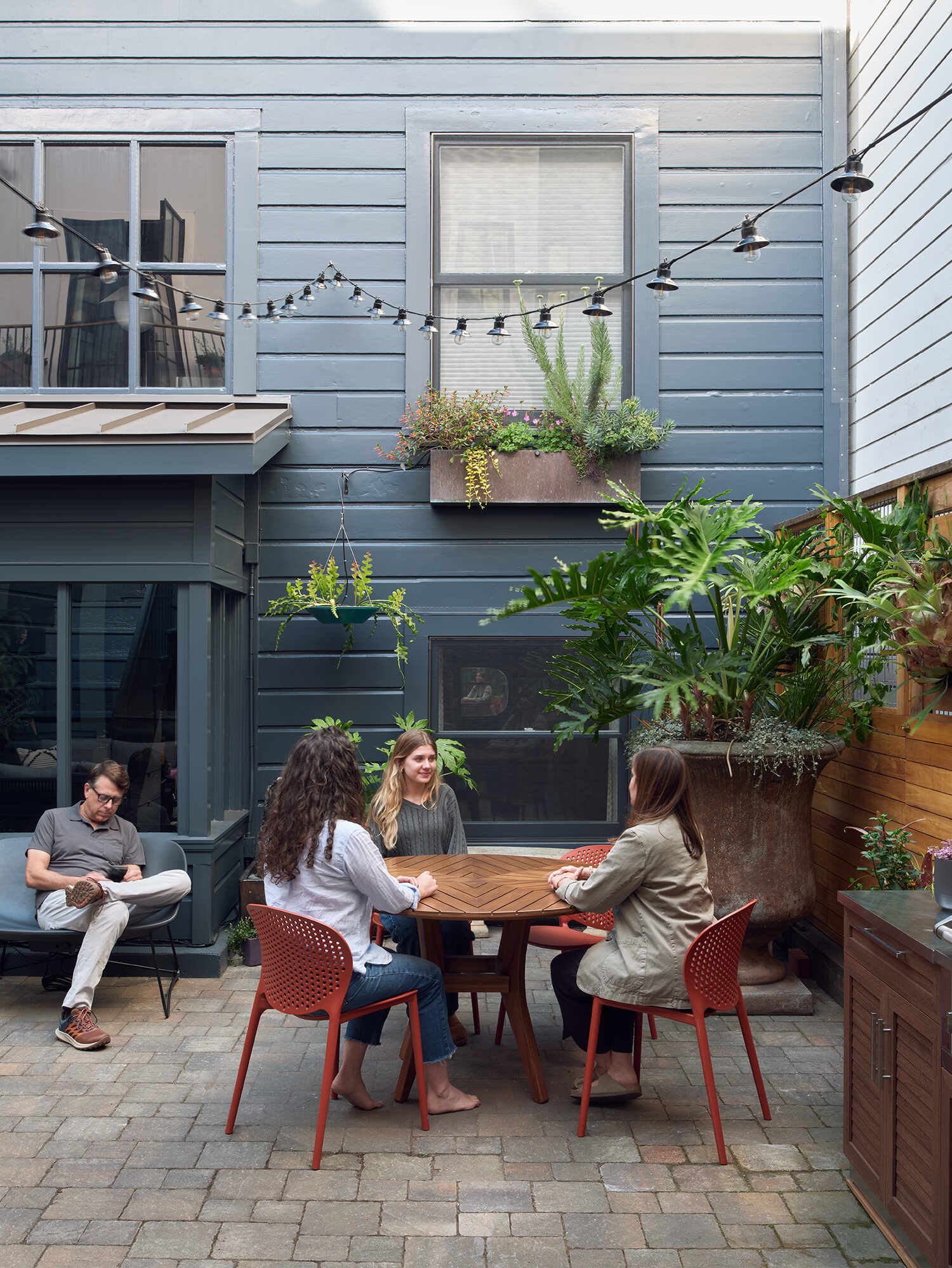 A private San Francisco courtyard links the main house and ADU, with steel-paned windows and doors opening the kitchen, dining room and primary bedroom onto the outdoor space.