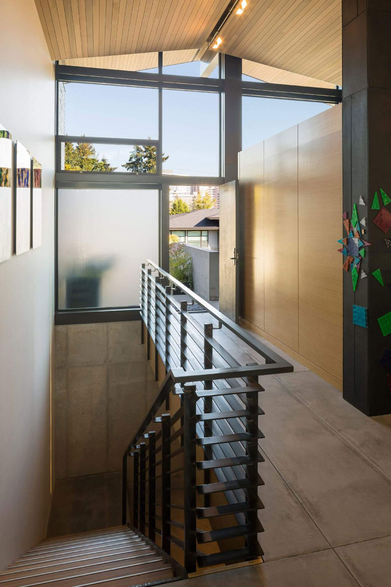A steel staircase near the entry leads to the garage, adding an industrial detail to the Bellevue home's mix of cedar, brick, steel and contemporary finishes.
