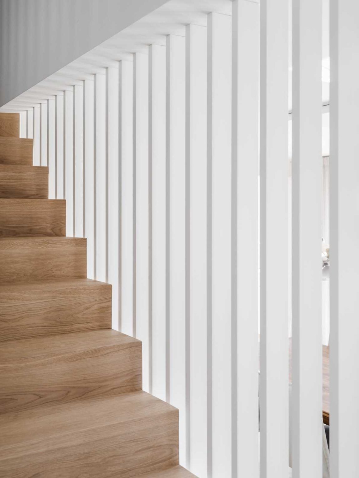 A clever under-stair room with a sink connects to a secondary living room hidden from the main communal spaces in this renovated Swiss home.