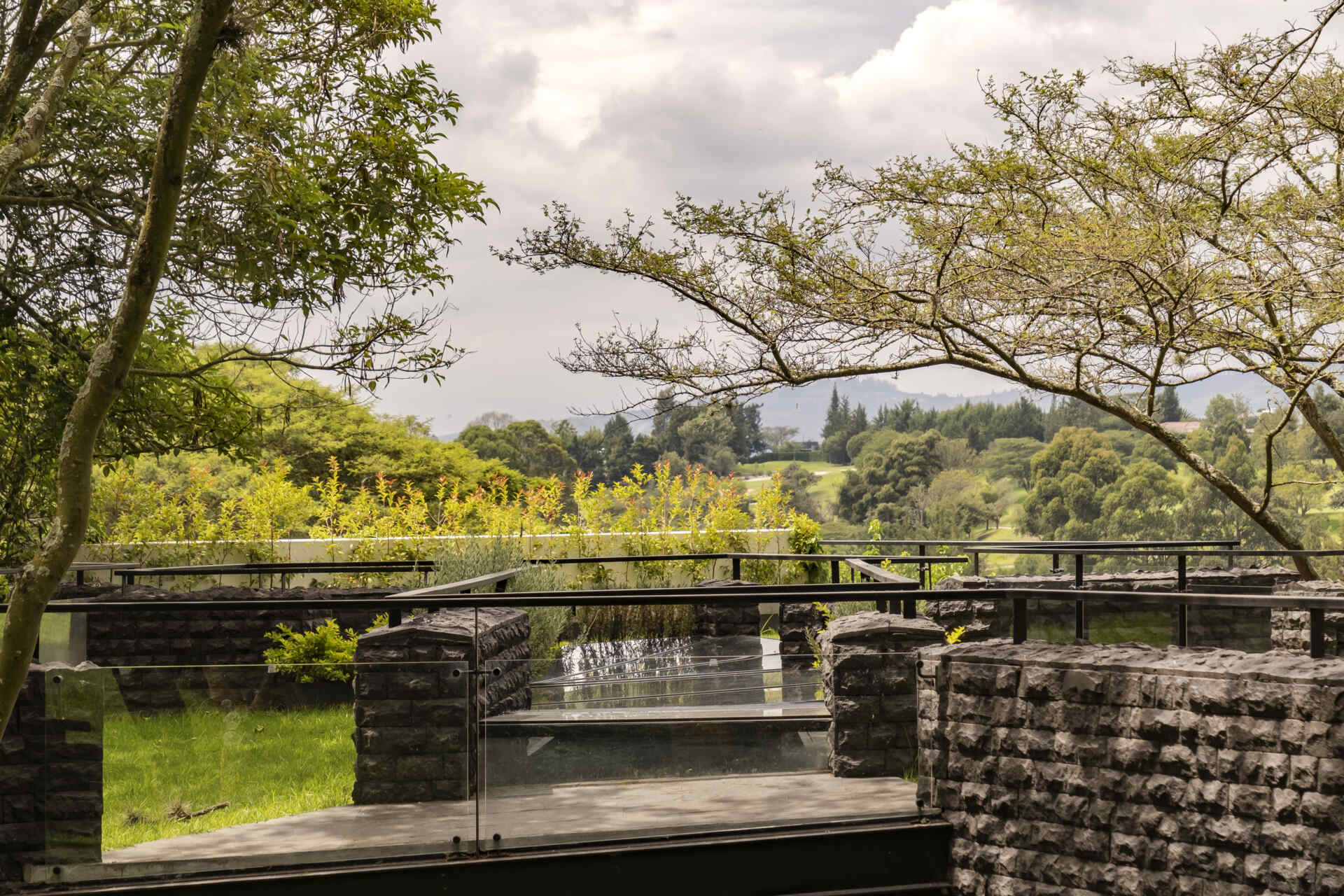 Discover the Hidden Stone House in Puembo, Ecuador, by A1 Arquitectura Avanzada, where biomimetic architecture brings the home and its existing trees together.