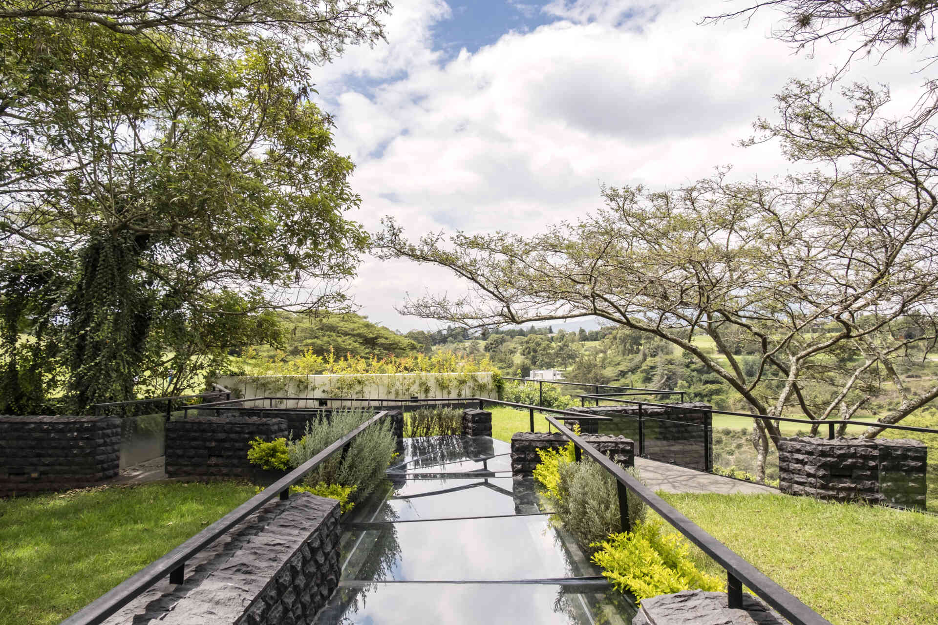Discover the Hidden Stone House in Puembo, Ecuador, by A1 Arquitectura Avanzada, where biomimetic architecture brings the home and its existing trees together.
