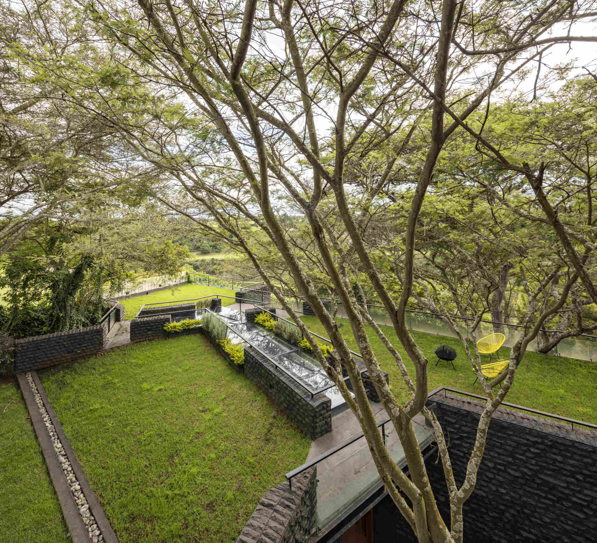 Discover the Hidden Stone House in Puembo, Ecuador, by A1 Arquitectura Avanzada, where biomimetic architecture brings the home and its existing trees together.