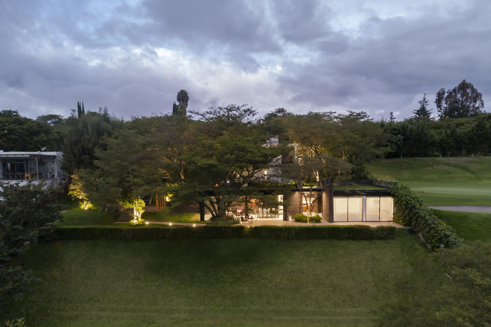 Discover the Hidden Stone House in Puembo, Ecuador, by A1 Arquitectura Avanzada, where biomimetic architecture brings the home and its existing trees together.