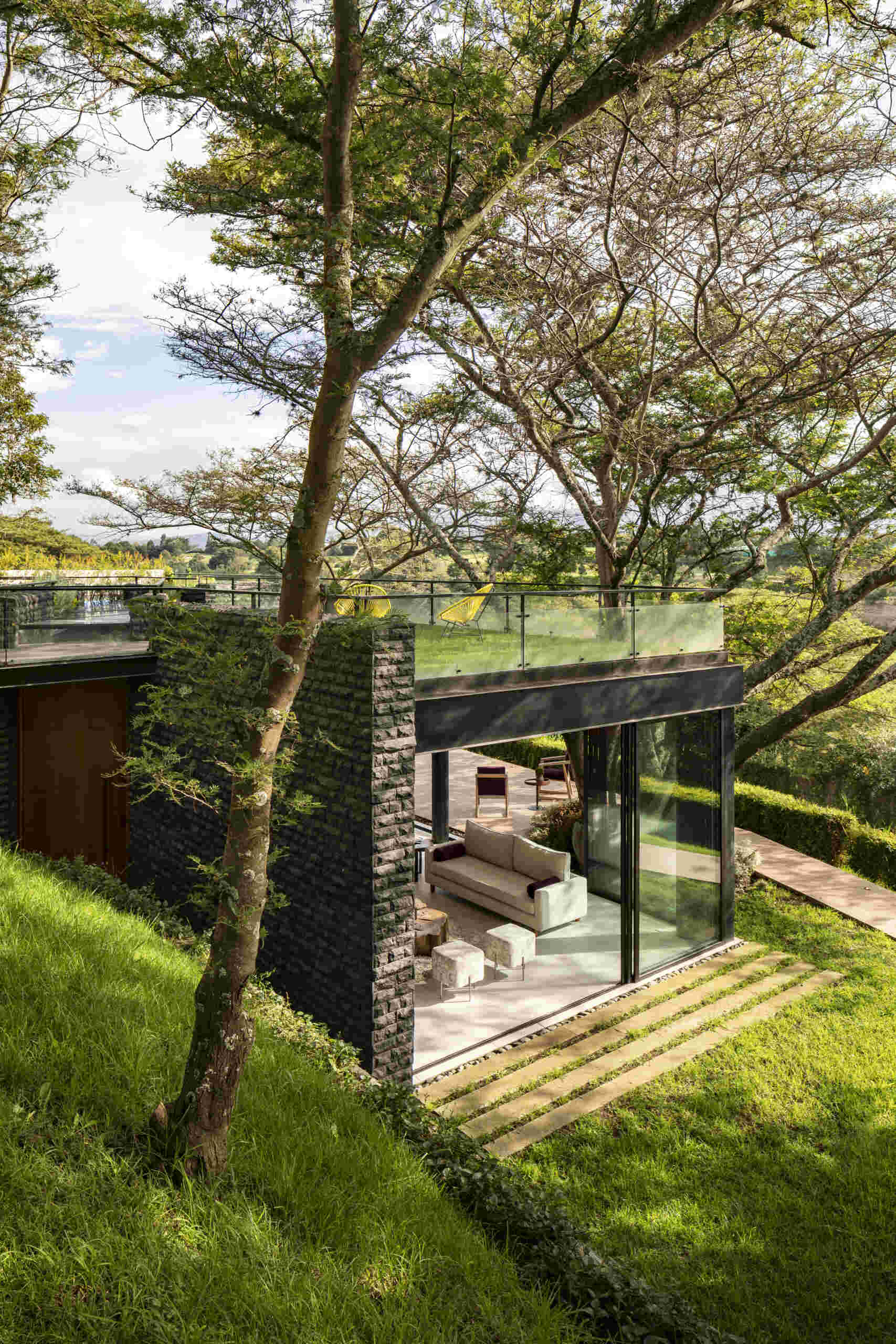 See how the Hidden Stone House uses its deck to create an outdoor space among mature trees, extending the home's relationship with nature.