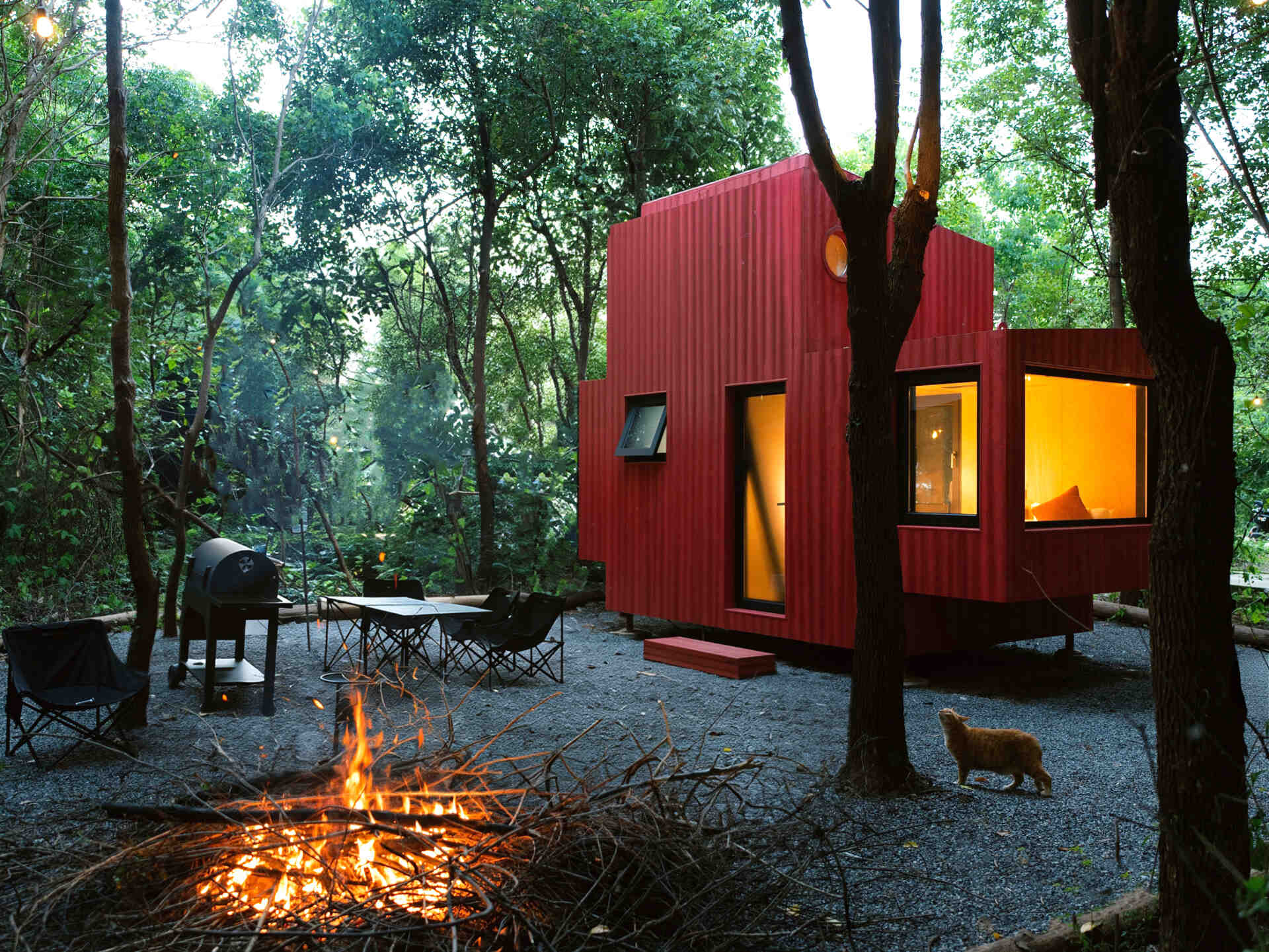 Wiki World’s Red Submarine Cabin brings the playful feeling of a submarine into the forest, with a vibrant red exterior, circular portholes and a compact timber interior.