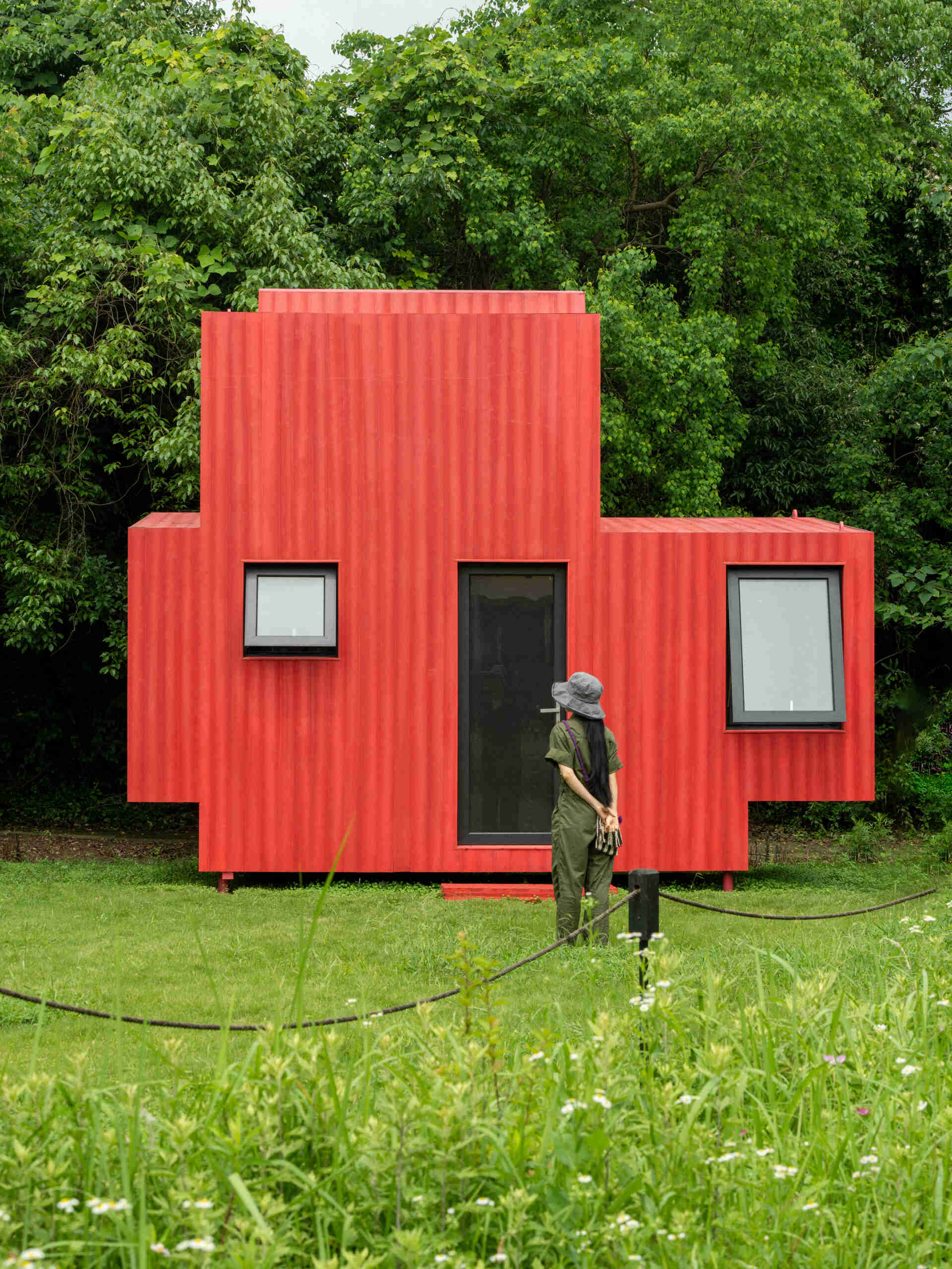 Wiki World’s Red Submarine Cabin brings the playful feeling of a submarine into the forest, with a vibrant red exterior, circular portholes and a compact timber interior.