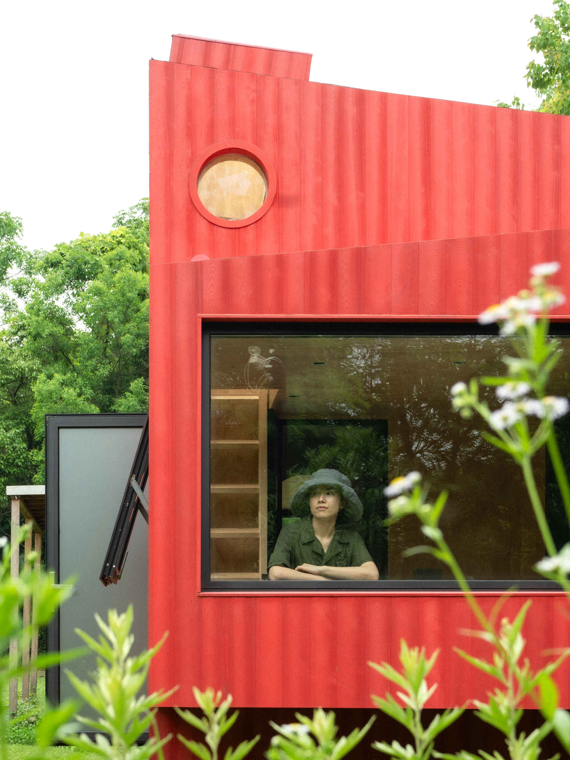 Wiki World’s Red Submarine Cabin brings the playful feeling of a submarine into the forest, with a vibrant red exterior, circular portholes and a compact timber interior.