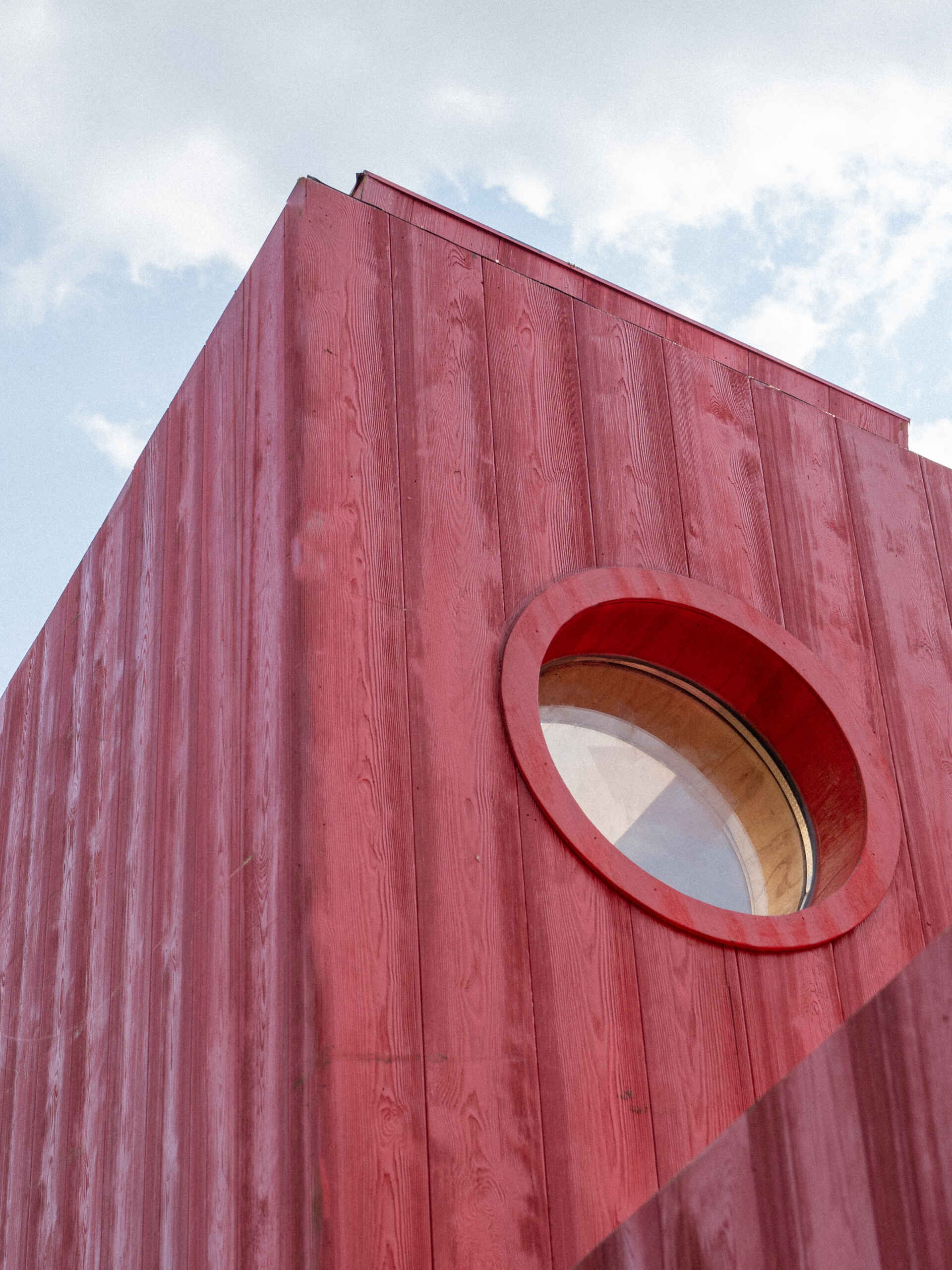Wiki World’s Red Submarine Cabin brings the playful feeling of a submarine into the forest, with a vibrant red exterior, circular portholes and a compact timber interior.