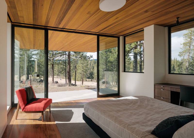 Explore the lower-level bedroom with sliding glass doors to a private patio, beneath the cantilevered master bedroom above.