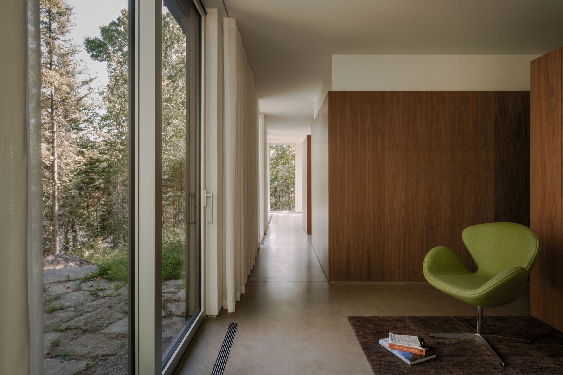 Discover the flexible ground-floor spaces of Chalet Moraine, including a multi-purpose room, hallway and bathroom organized around the home's distinctive interior volumes.