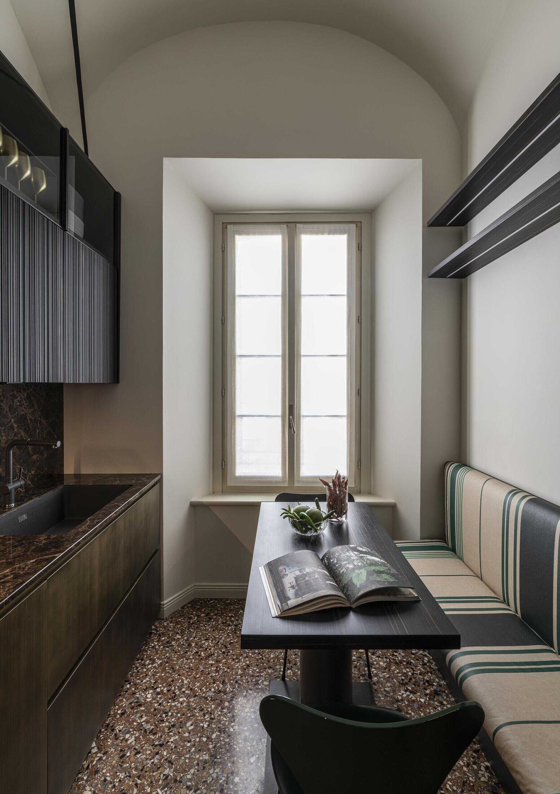 A compact Italian kitchen combines burnished brass cabinetry, irregular wooden reeded panelling and bespoke furniture designed specifically for a young family.