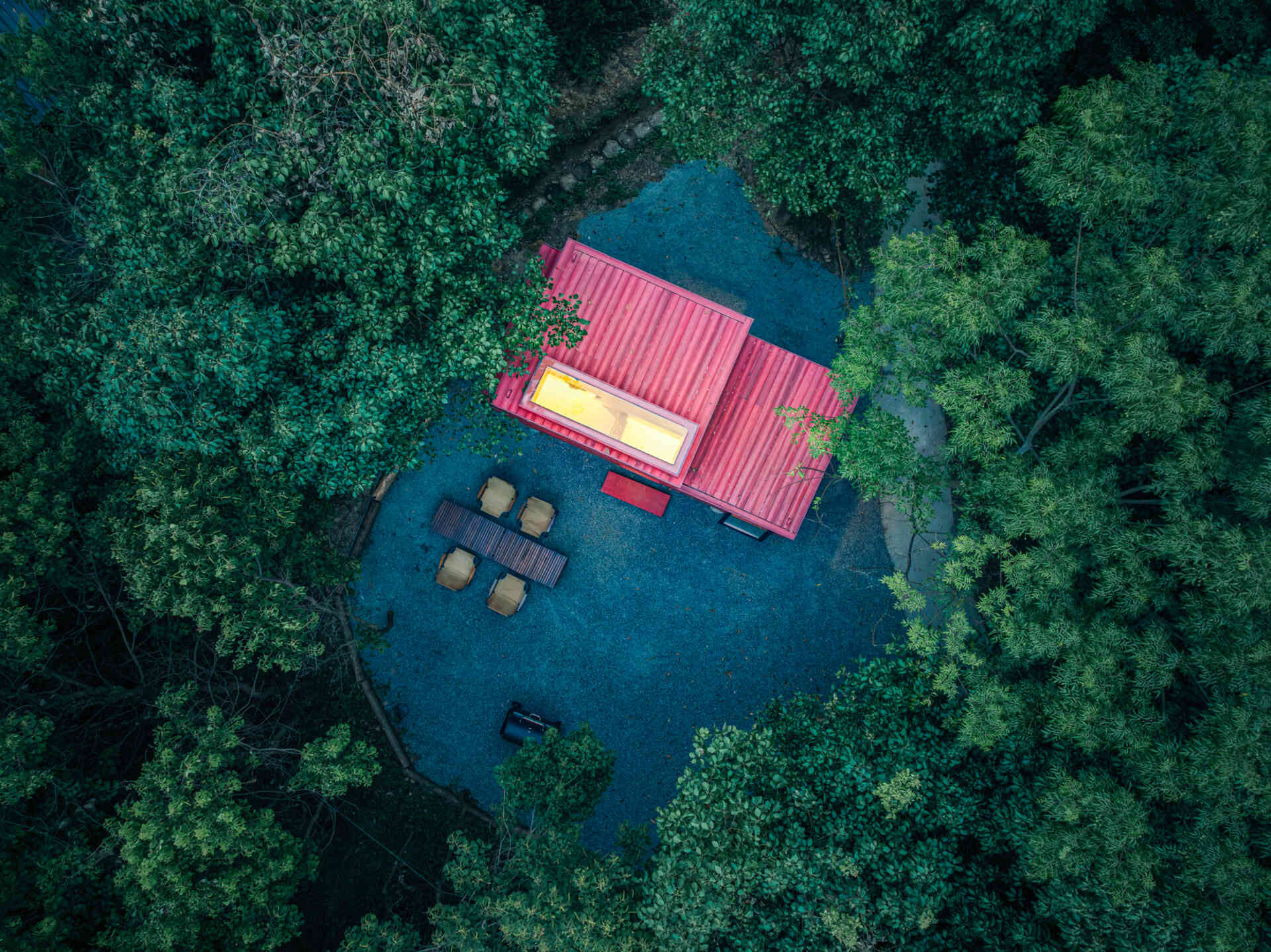 Wiki World’s Red Submarine Cabin brings the playful feeling of a submarine into the forest, with a vibrant red exterior, circular portholes and a compact timber interior.