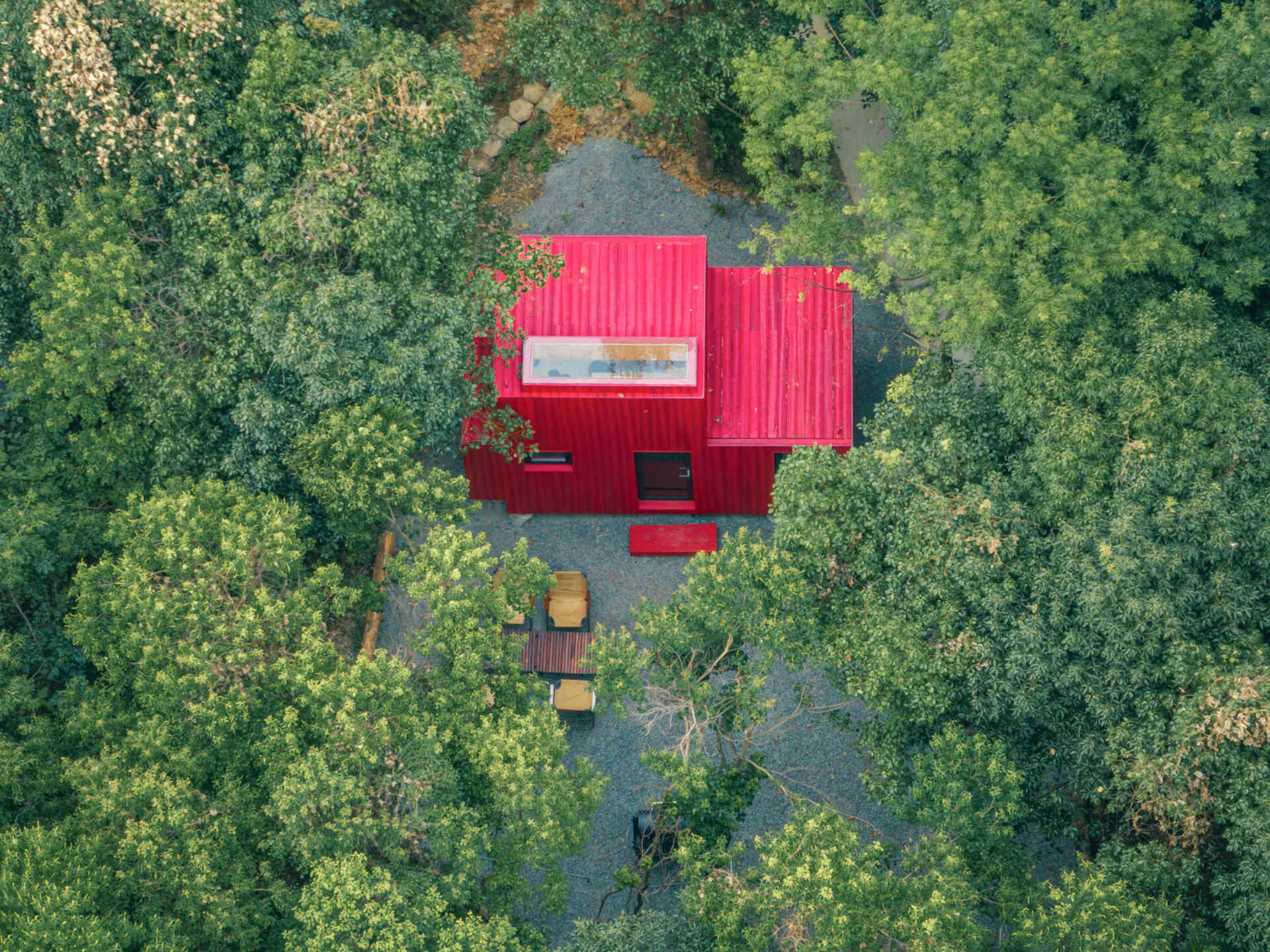 Wiki World’s Red Submarine Cabin brings the playful feeling of a submarine into the forest, with a vibrant red exterior, circular portholes and a compact timber interior.