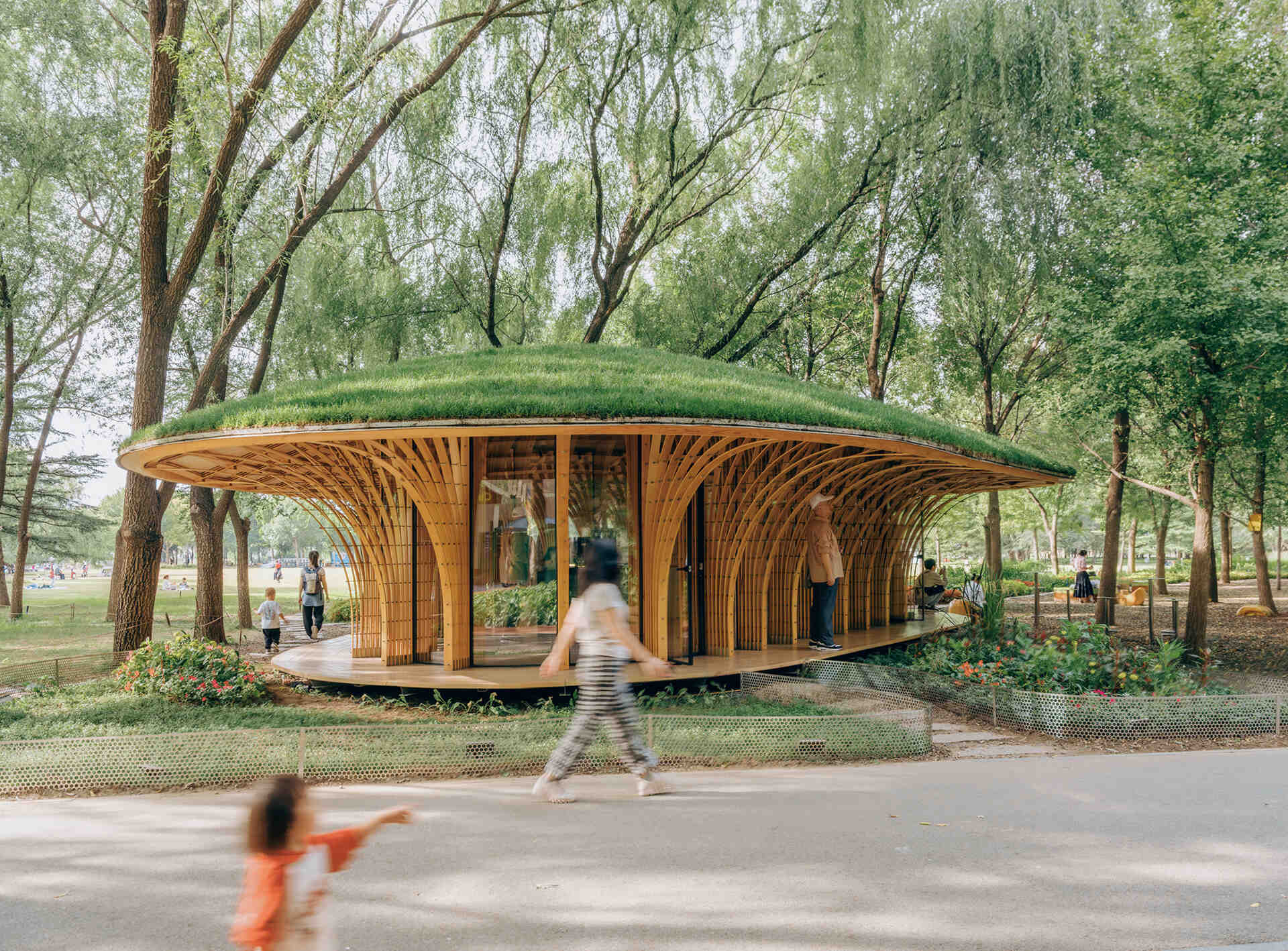 West Garden Florist by LUO studio is a mushroom-like timber florist pavilion tucked among the trees of Haidian Park in Beijing, with a planted roof and open canopy.