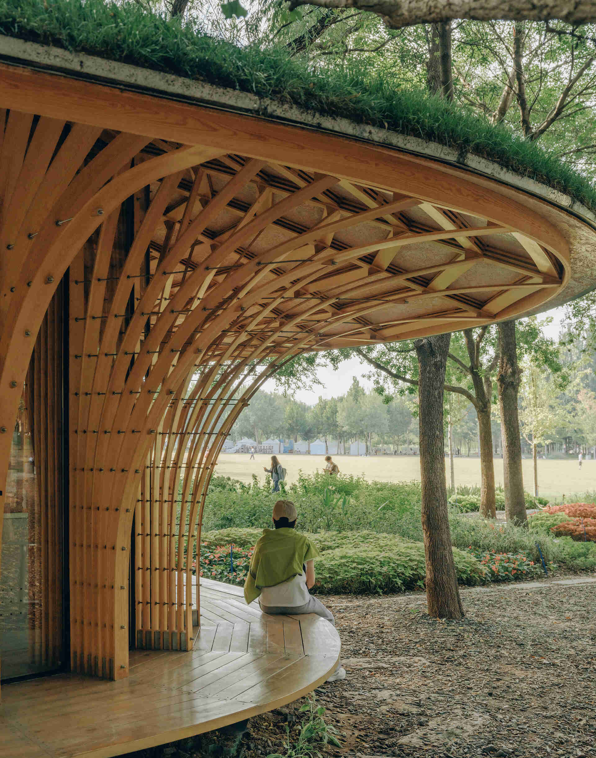 West Garden Florist by LUO studio is a mushroom-like timber florist pavilion tucked among the trees of Haidian Park in Beijing, with a planted roof and open canopy.