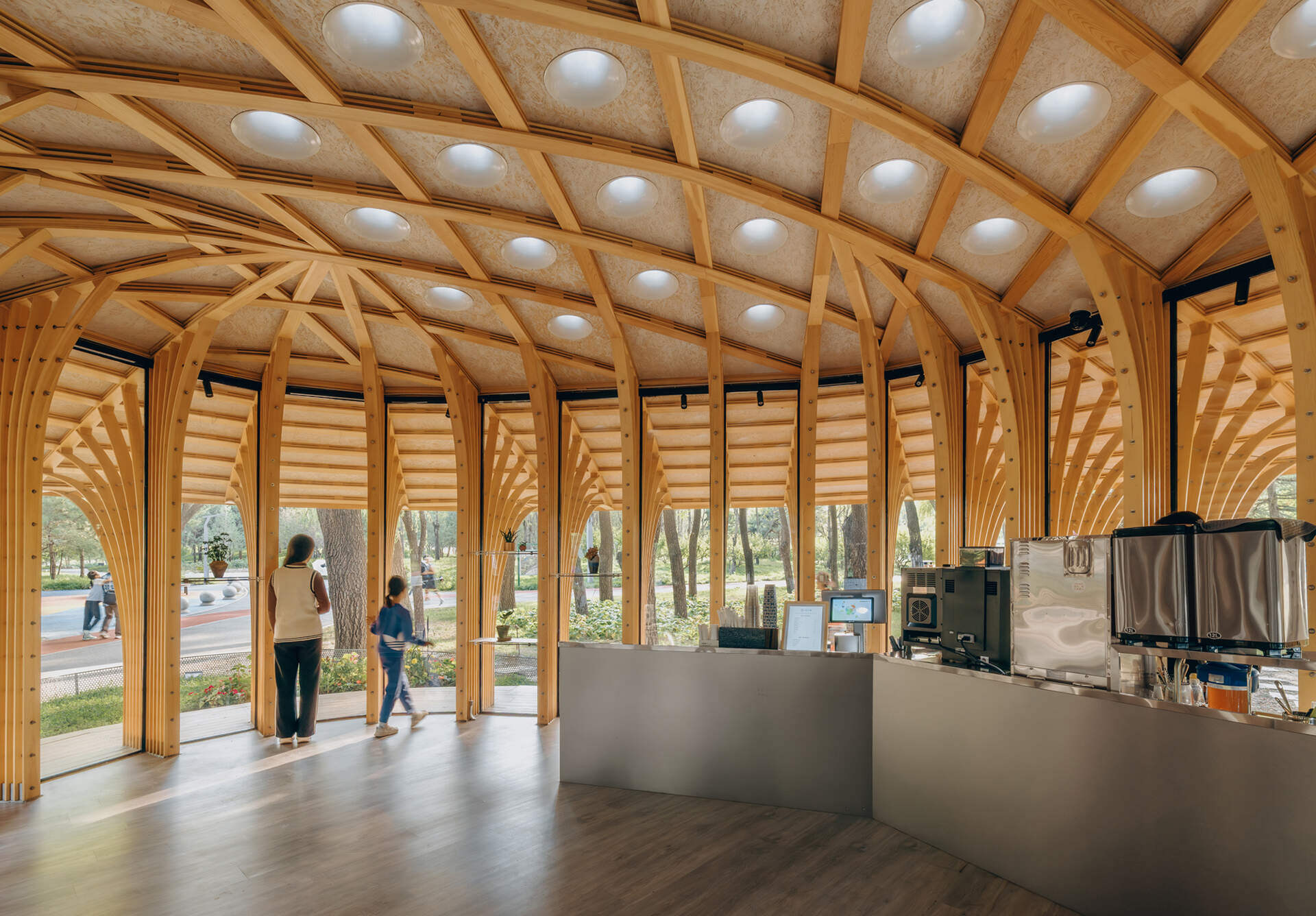 West Garden Florist by LUO studio is a mushroom-like timber florist pavilion tucked among the trees of Haidian Park in Beijing, with a planted roof and open canopy.