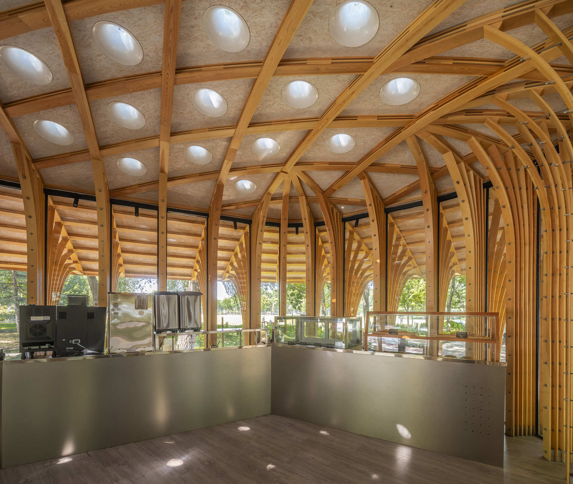 West Garden Florist by LUO studio is a mushroom-like timber florist pavilion tucked among the trees of Haidian Park in Beijing, with a planted roof and open canopy.
