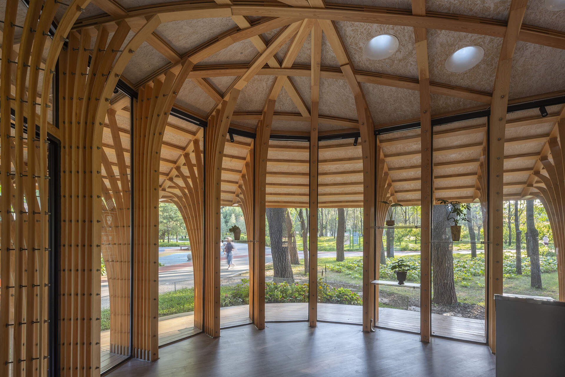 West Garden Florist by LUO studio is a mushroom-like timber florist pavilion tucked among the trees of Haidian Park in Beijing, with a planted roof and open canopy.