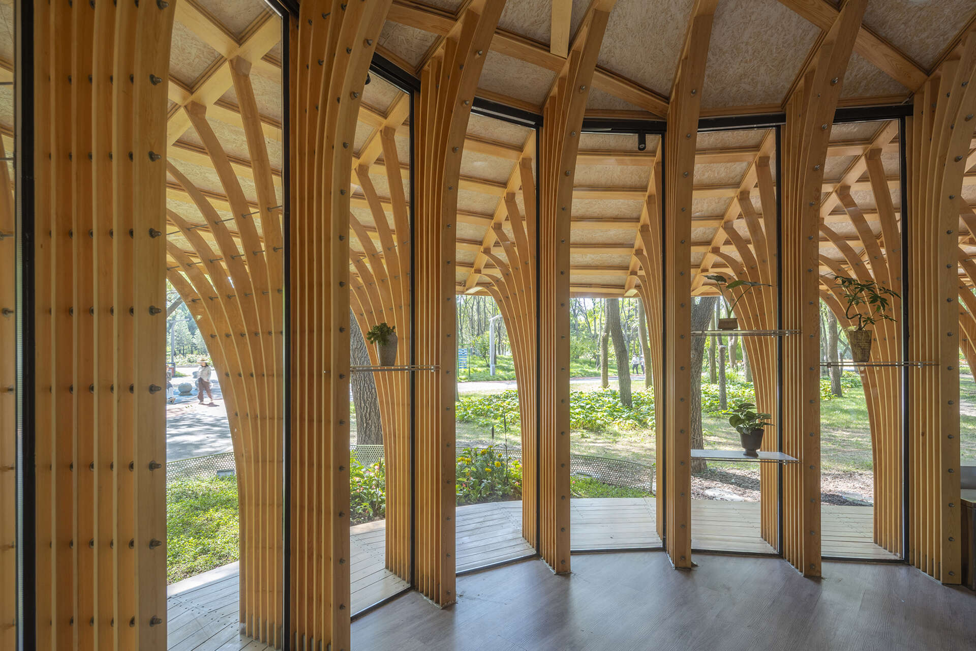 West Garden Florist by LUO studio is a mushroom-like timber florist pavilion tucked among the trees of Haidian Park in Beijing, with a planted roof and open canopy.