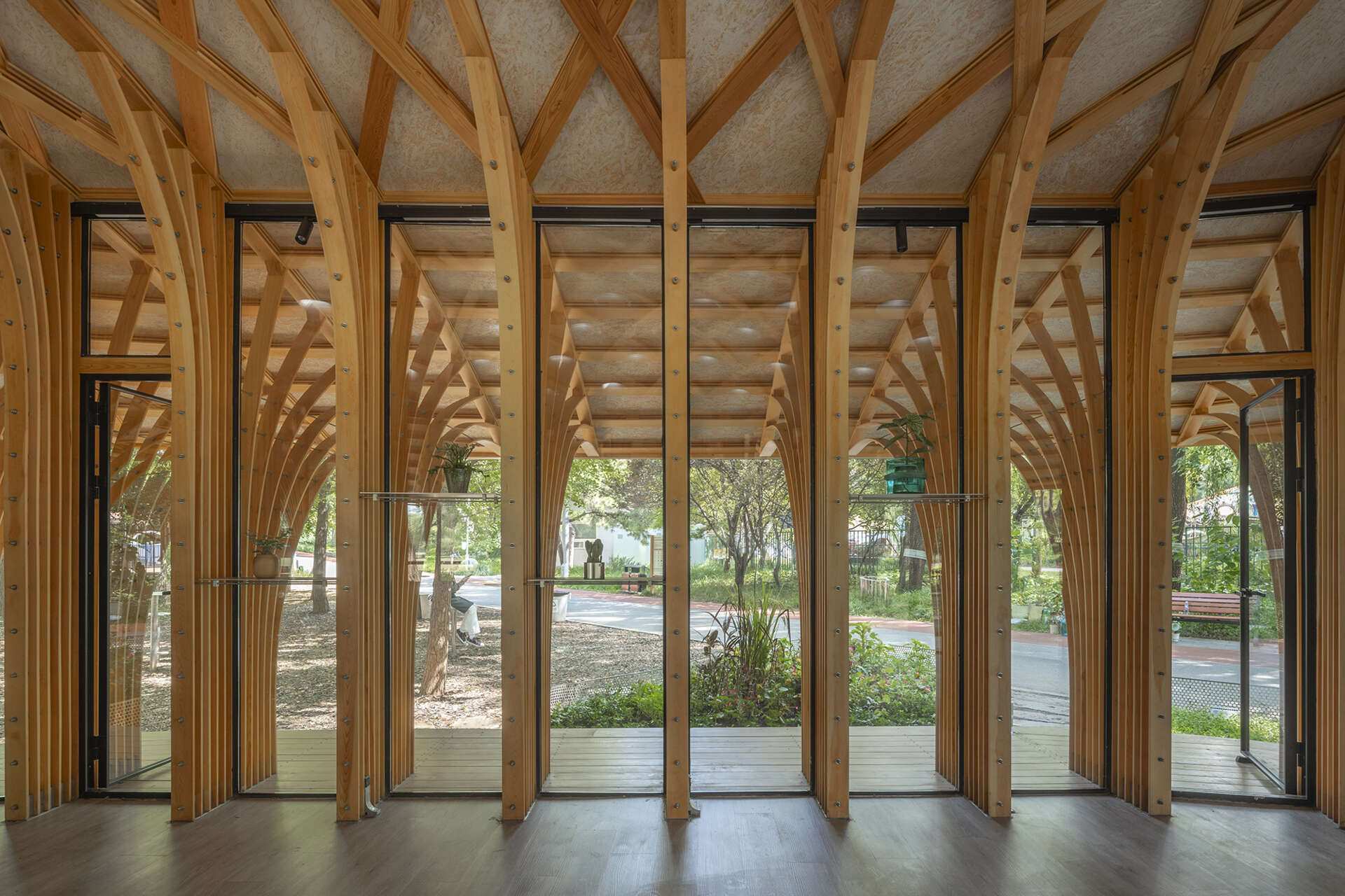 West Garden Florist by LUO studio is a mushroom-like timber florist pavilion tucked among the trees of Haidian Park in Beijing, with a planted roof and open canopy.