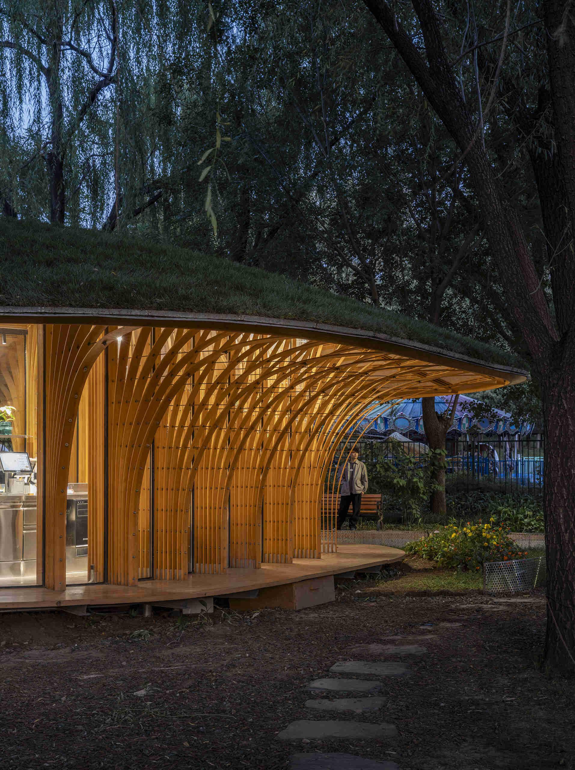 West Garden Florist by LUO studio is a mushroom-like timber florist pavilion tucked among the trees of Haidian Park in Beijing, with a planted roof and open canopy.
