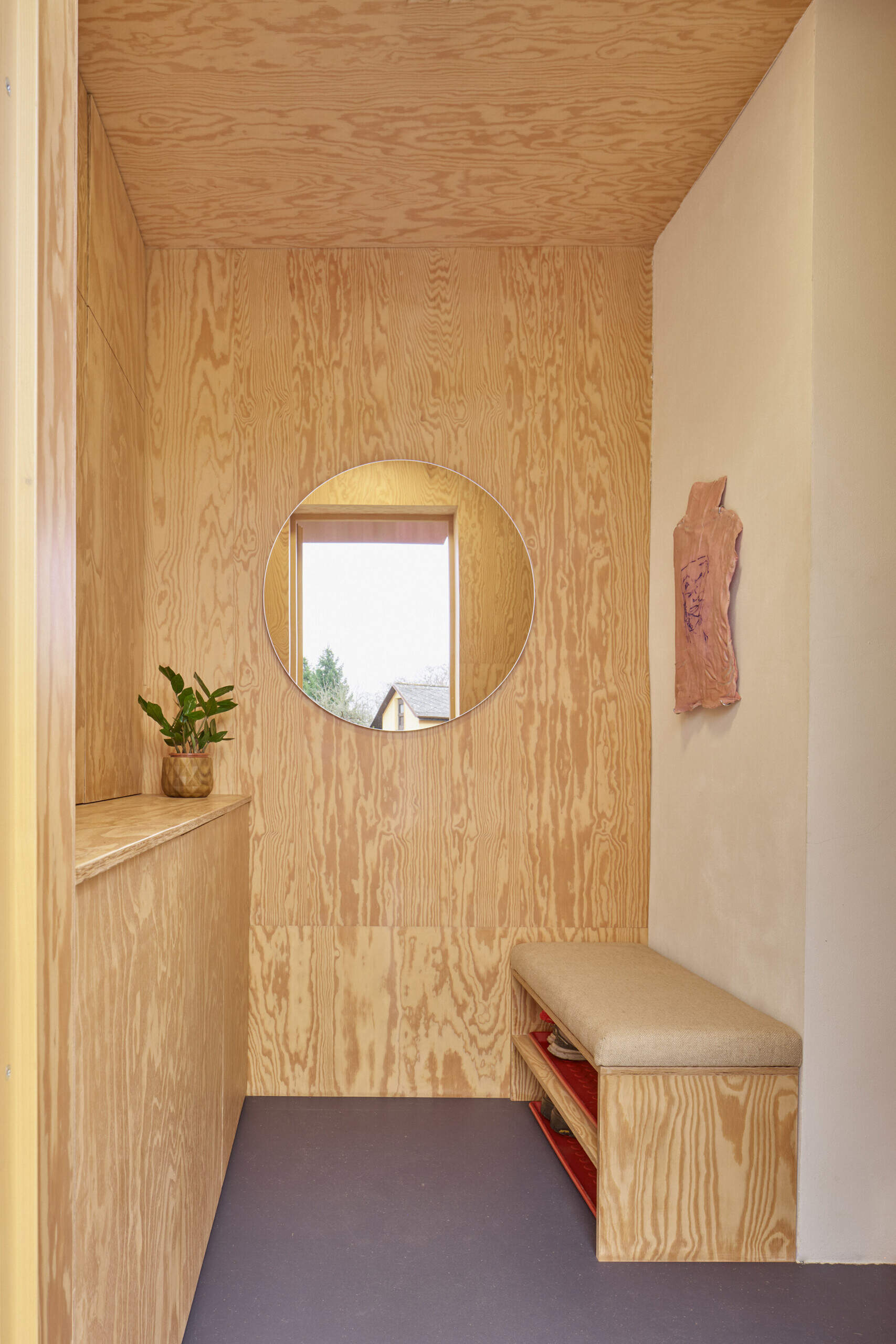 Inside the extension by Facha architekti, pine plywood wraps the entryway and hallway, with built-in storage and custom furniture helping make the most of the compact family home in Ne?ín, Czech Republic.