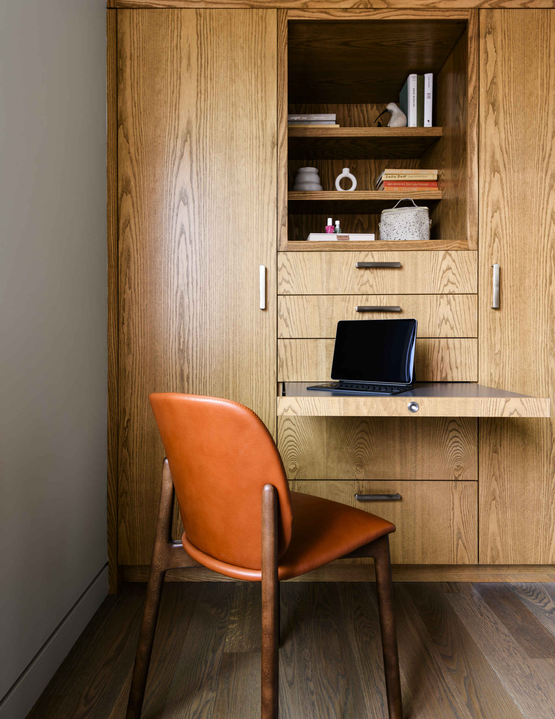Custom wood bunk beds, botanical ceiling wallpaper, floral bedding, sculptural pendant lights, and a built-in desk create a cozy and practical kids' bedroom.