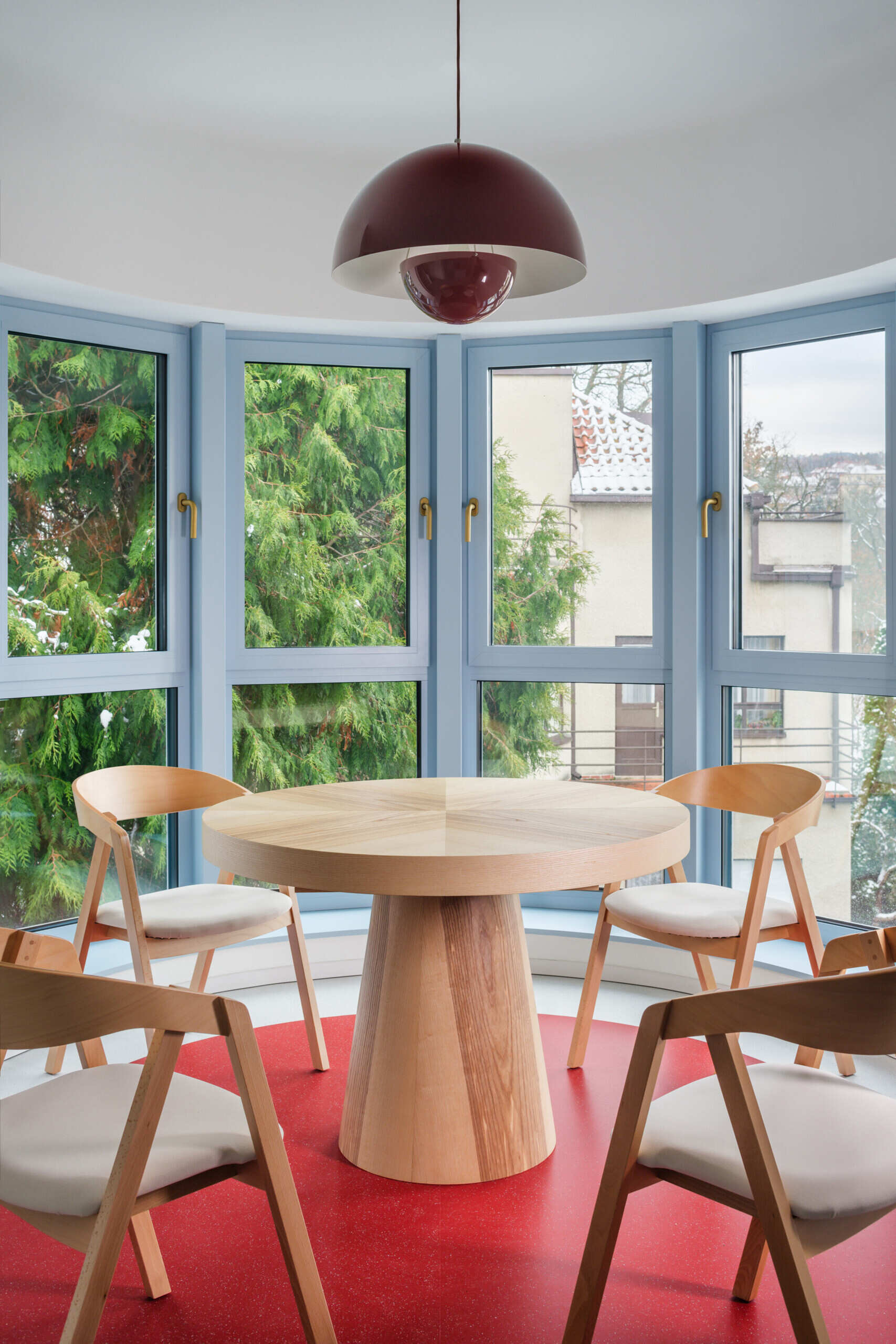 Explore the colorful living spaces of Blue Window House, where mustard-yellow seating, red pendant lights, warm wood cabinetry, and pale blue kitchens create playful contemporary interiors. Curved furniture, built-in storage, and custom joinery add character throughout the renovated home.