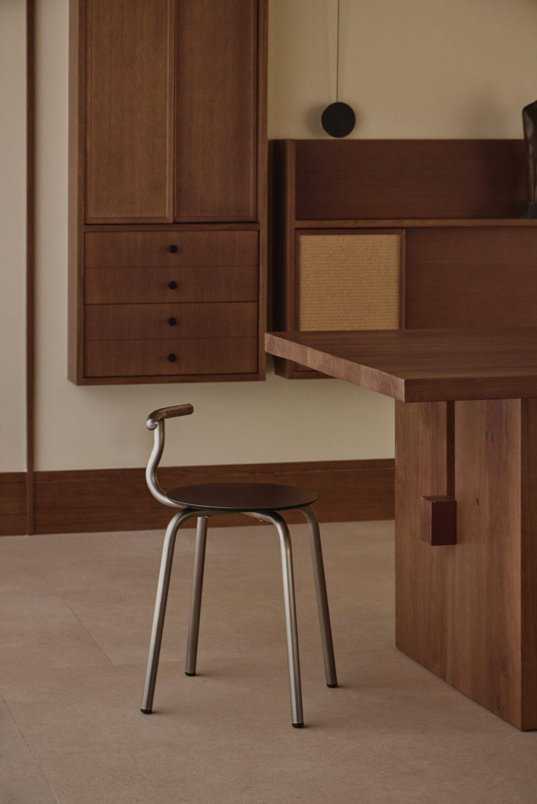 This contemporary dining room by Viruta Lab features a custom walnut dining table, metal-framed chairs, natural woven cabinetry, minimalist lighting, and sculptural decor.