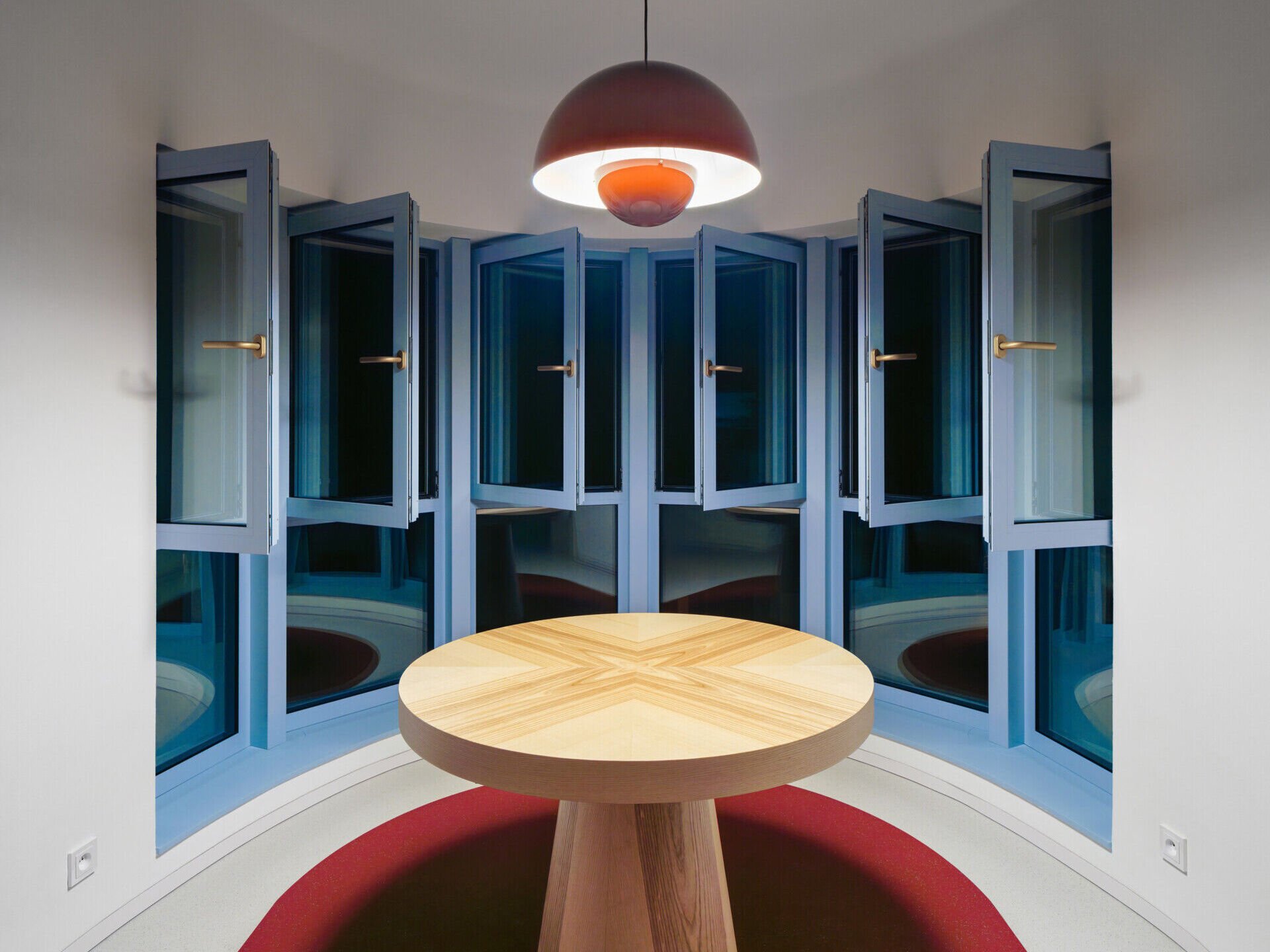 Discover the exterior transformation of Blue Window House in Prague, Czech Republic, by No Architects. The renovated modernist home features a white facade, curved window bays, distinctive blue aluminum window frames, and a redesigned garden.