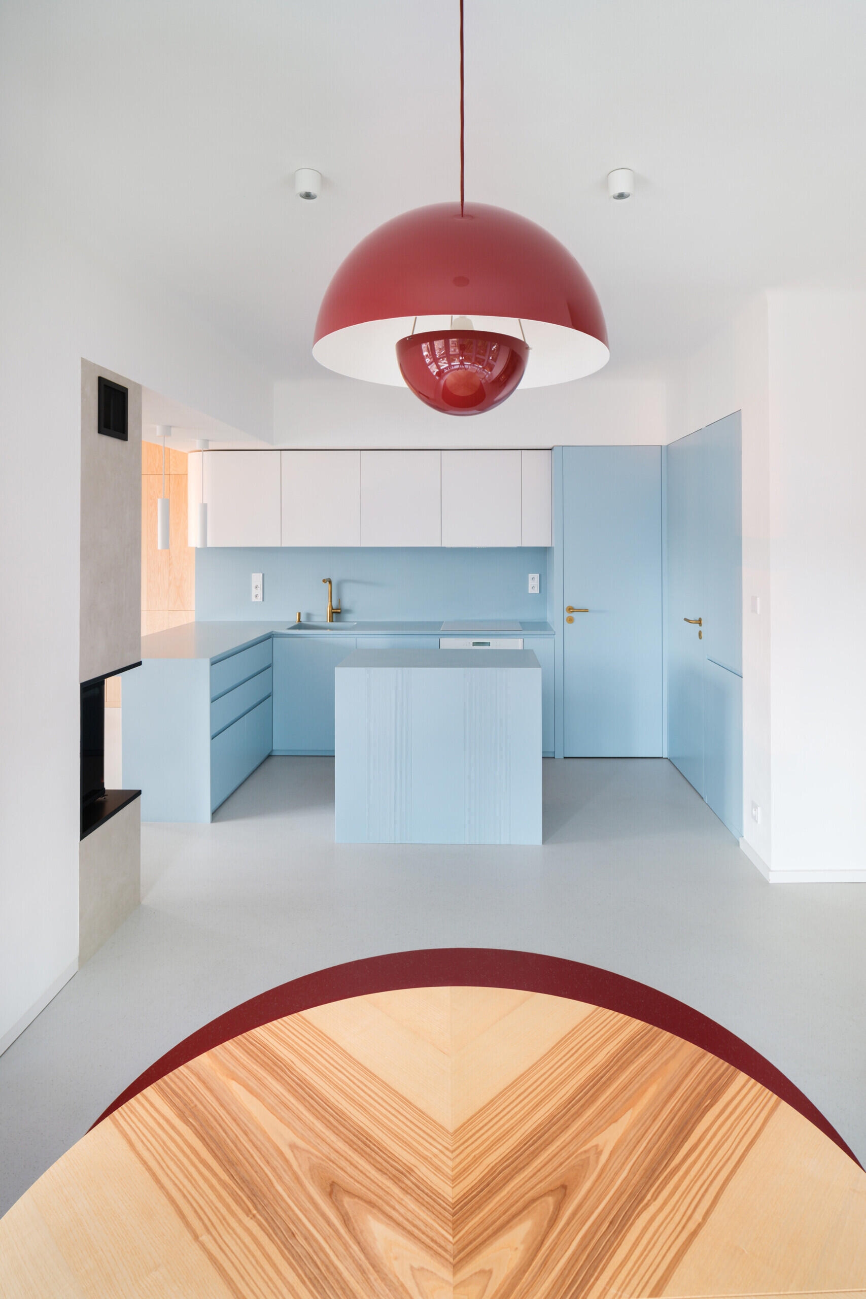 Explore the colorful living spaces of Blue Window House, where mustard-yellow seating, red pendant lights, warm wood cabinetry, and pale blue kitchens create playful contemporary interiors. Curved furniture, built-in storage, and custom joinery add character throughout the renovated home.