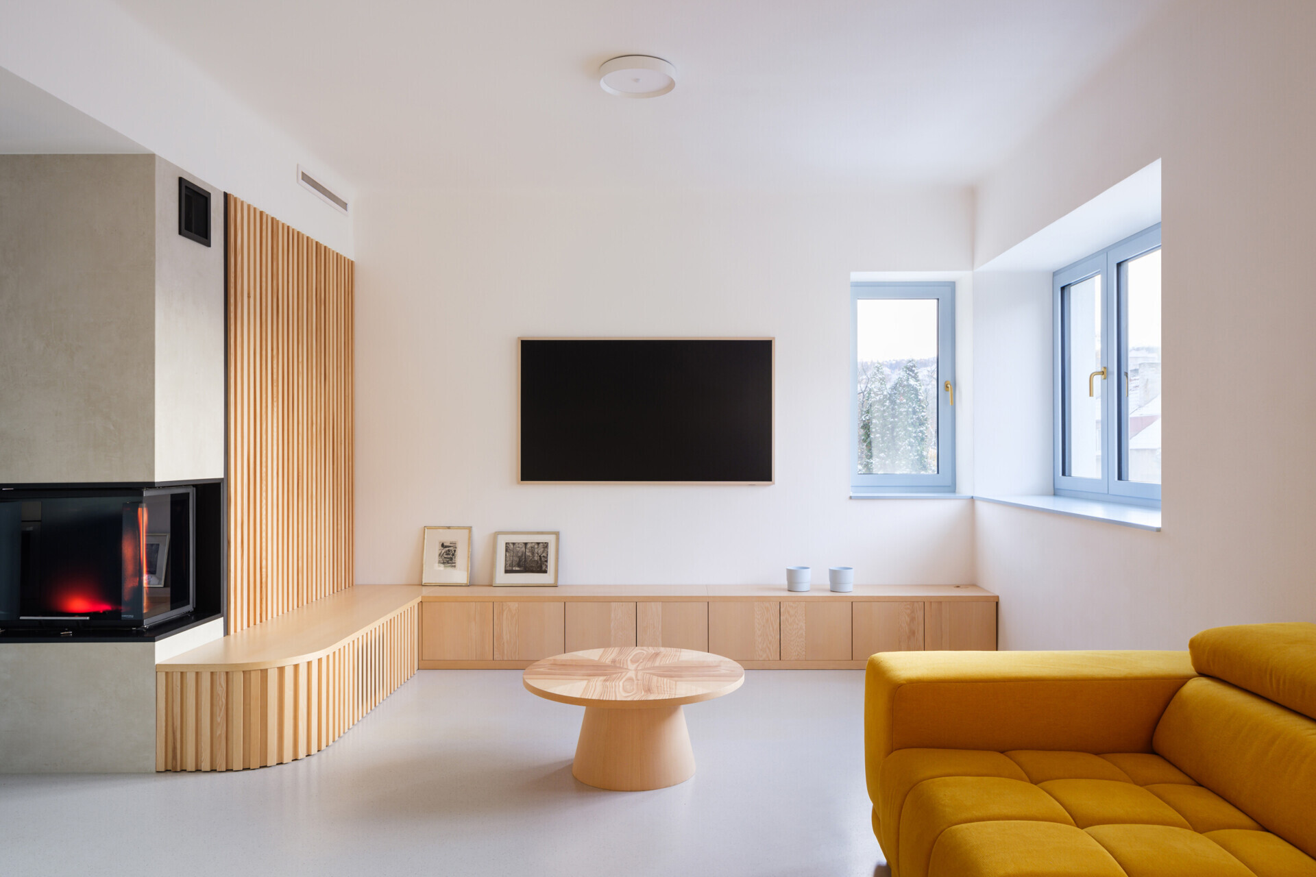 Explore the colorful living spaces of Blue Window House, where mustard-yellow seating, red pendant lights, warm wood cabinetry, and pale blue kitchens create playful contemporary interiors. Curved furniture, built-in storage, and custom joinery add character throughout the renovated home.