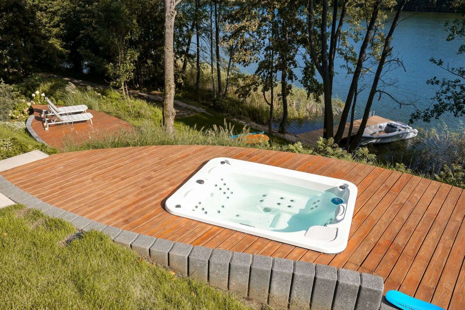 Explore the lakeside decks of this contemporary Polish holiday home, complete with outdoor lounge furniture, sun loungers, a hot tub, and a private jetty overlooking Lake D?browa Wielka.