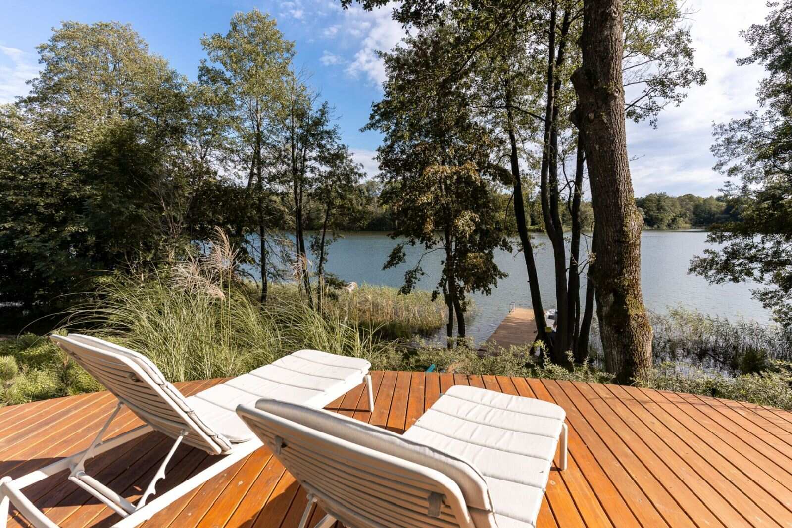 Explore the lakeside decks of this contemporary Polish holiday home, complete with outdoor lounge furniture, sun loungers, a hot tub, and a private jetty overlooking Lake D?browa Wielka.