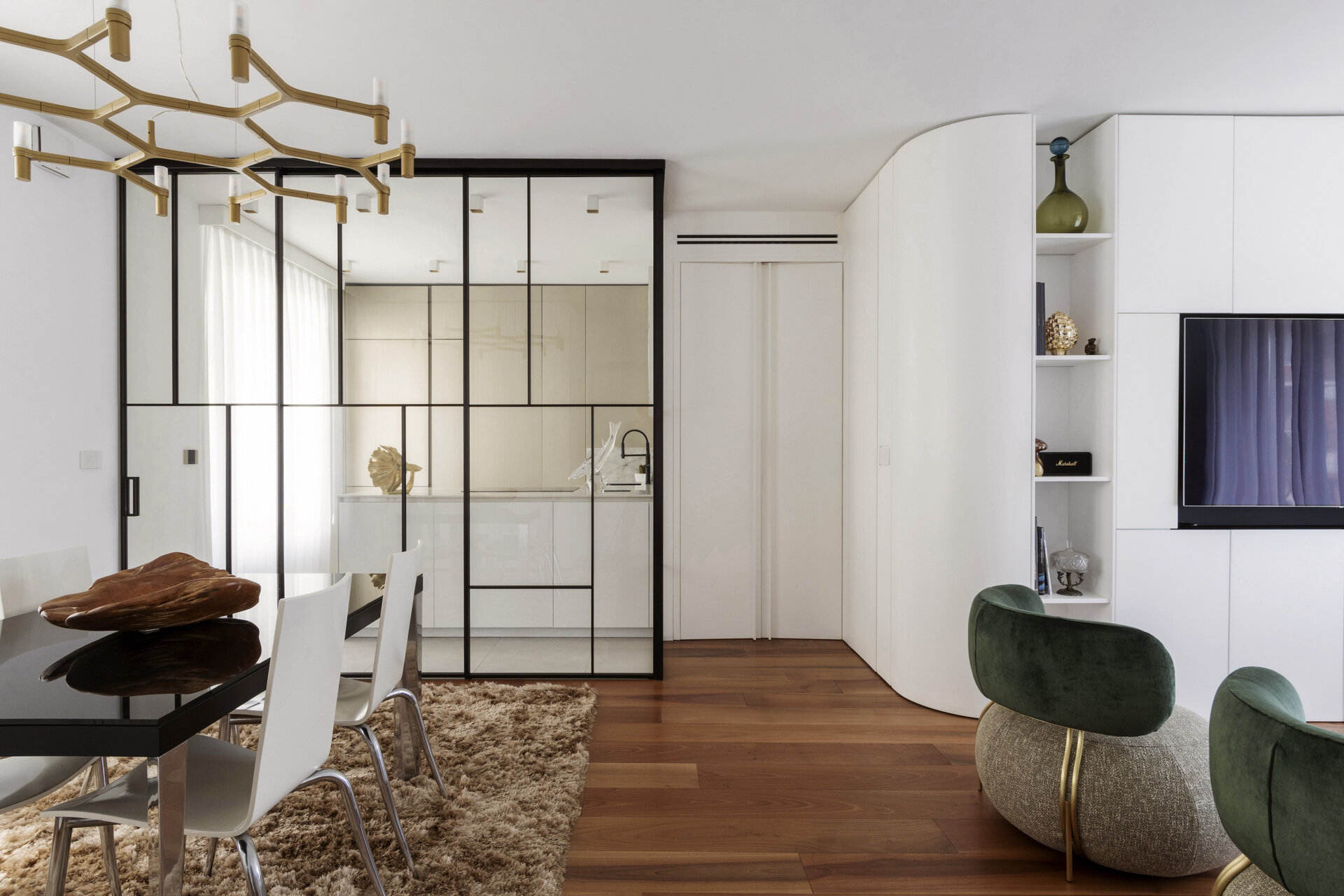 Curved white cabinetry conceals a hallway entrance in this Italian apartment, with flush doors, integrated storage, and custom wall panelling.