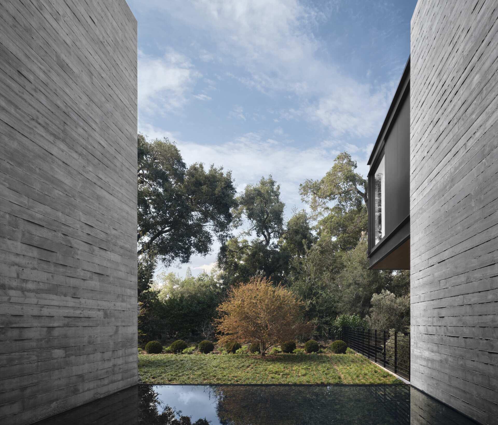 Discover modern architectural water features at this California home by Olson Kundig. Shallow reflecting pools, sculptural artwork, concrete courtyard walls, and floating stepping stones create beautiful outdoor spaces between the home's contemporary buildings.