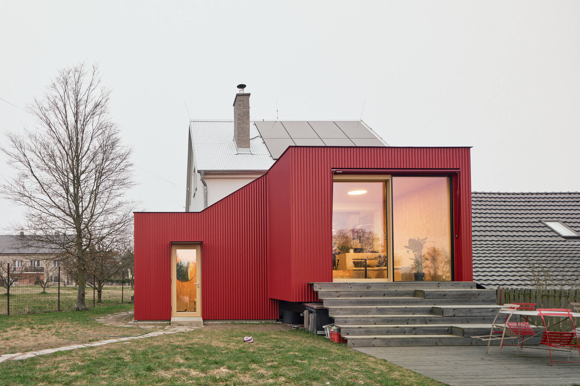See how Facha architekti extended this small home in Ne?ín, Czech Republic, with a timber-framed addition wrapped in red corrugated metal. The new volume sits clearly against the older house, adding living space and a contemporary new layer to its evolving architecture.