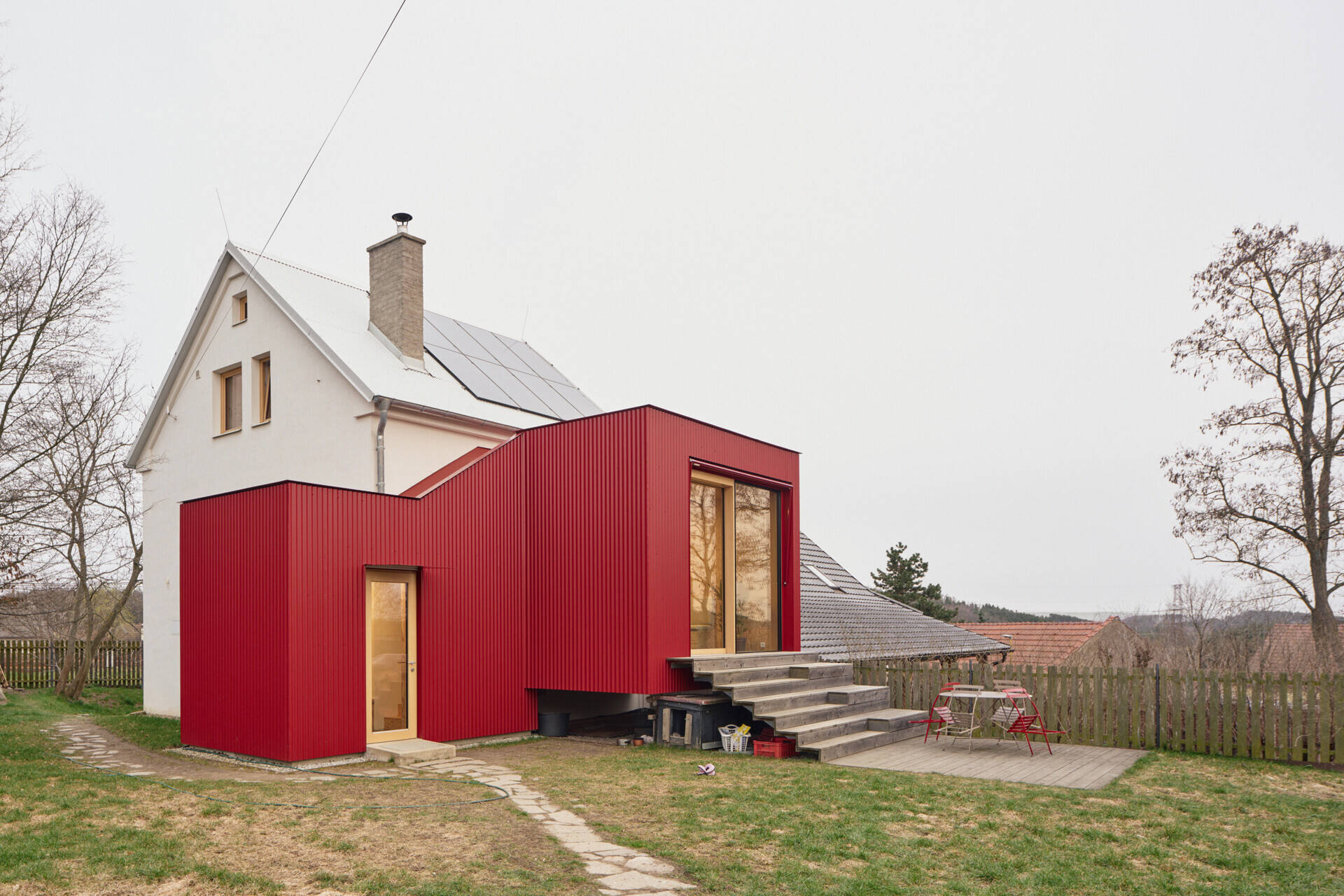 See how Facha architekti extended this small home in Ne?ín, Czech Republic, with a timber-framed addition wrapped in red corrugated metal. The new volume sits clearly against the older house, adding living space and a contemporary new layer to its evolving architecture.