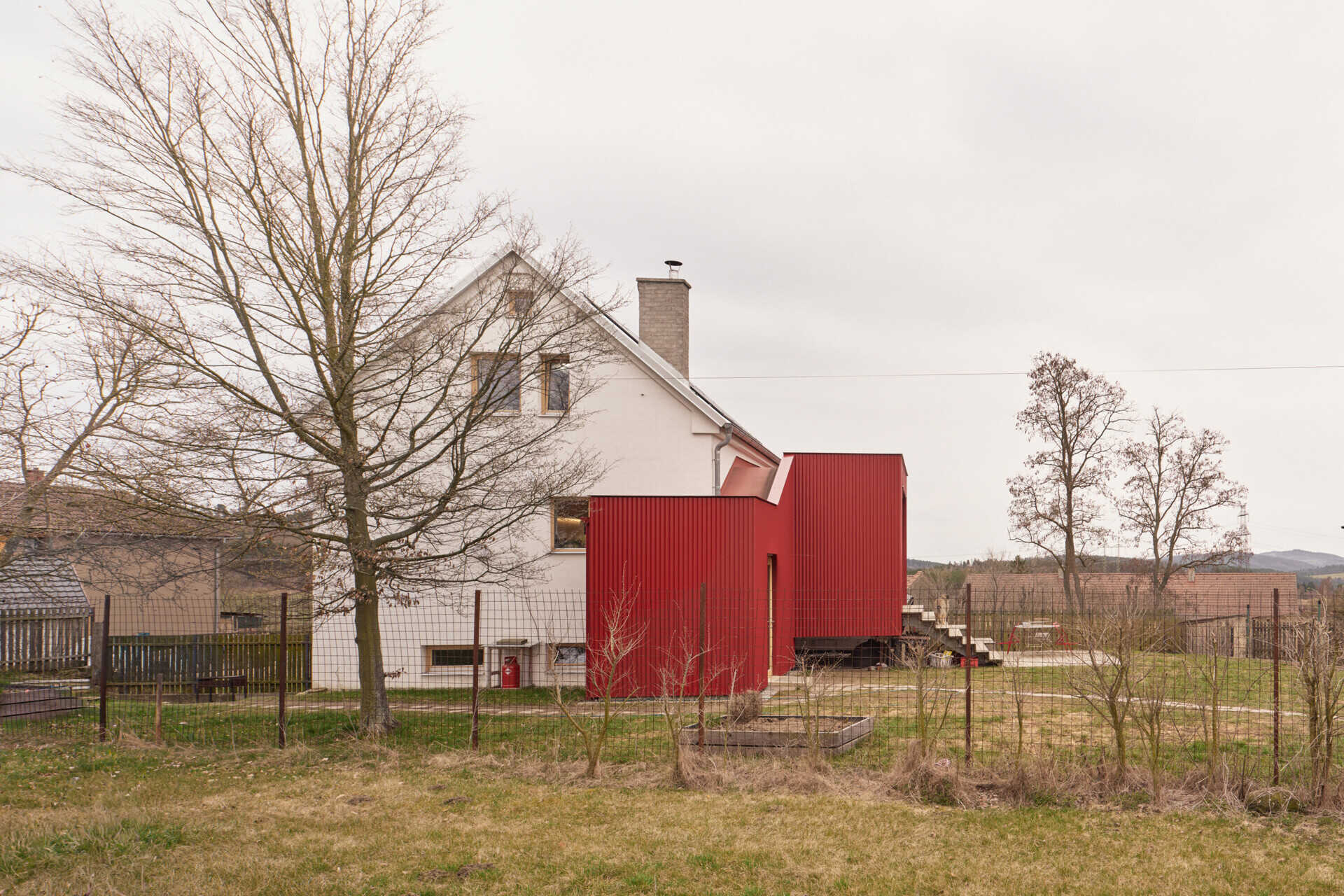 See how Facha architekti extended this small home in Ne?ín, Czech Republic, with a timber-framed addition wrapped in red corrugated metal. The new volume sits clearly against the older house, adding living space and a contemporary new layer to its evolving architecture.
