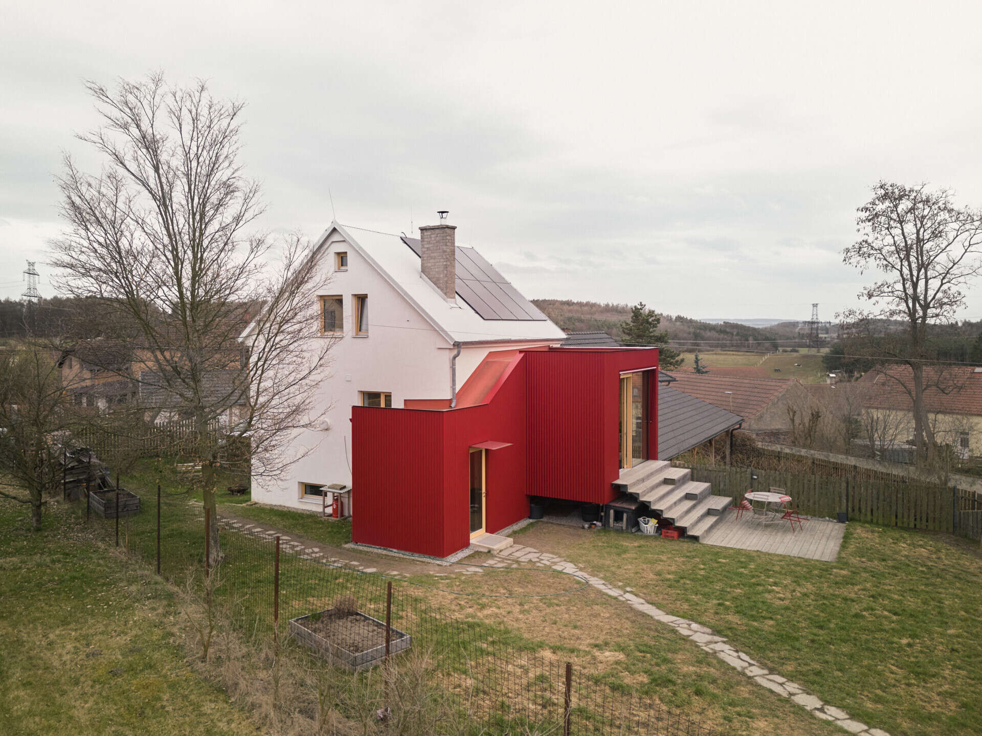 See how Facha architekti extended this small home in Ne?ín, Czech Republic, with a timber-framed addition wrapped in red corrugated metal. The new volume sits clearly against the older house, adding living space and a contemporary new layer to its evolving architecture.