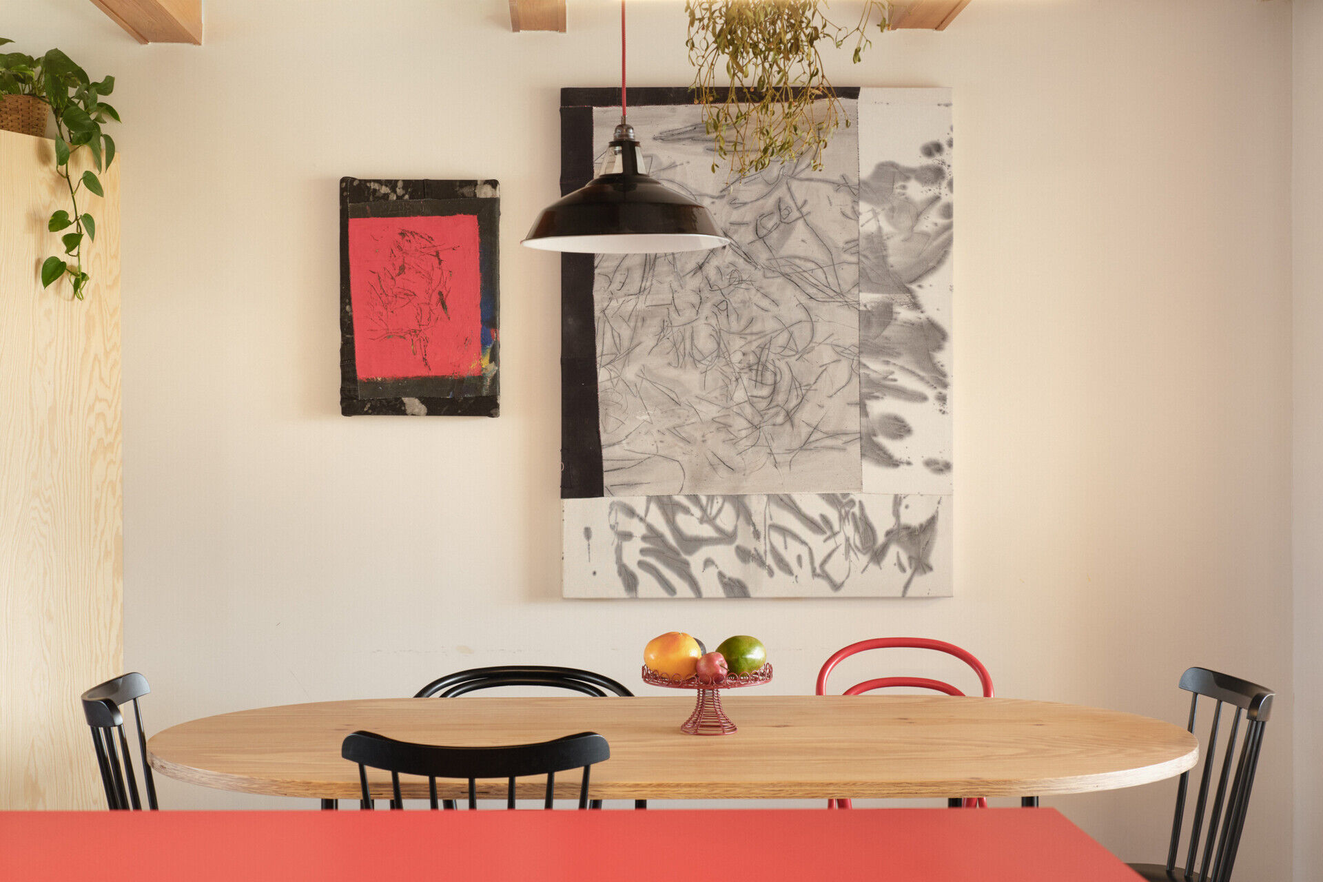 The redesigned kitchen and dining area in this Ne?ín home by Facha architekti combines custom pine plywood cabinetry, natural linoleum flooring and a rotating wood-burning stove within the reworked ground floor.