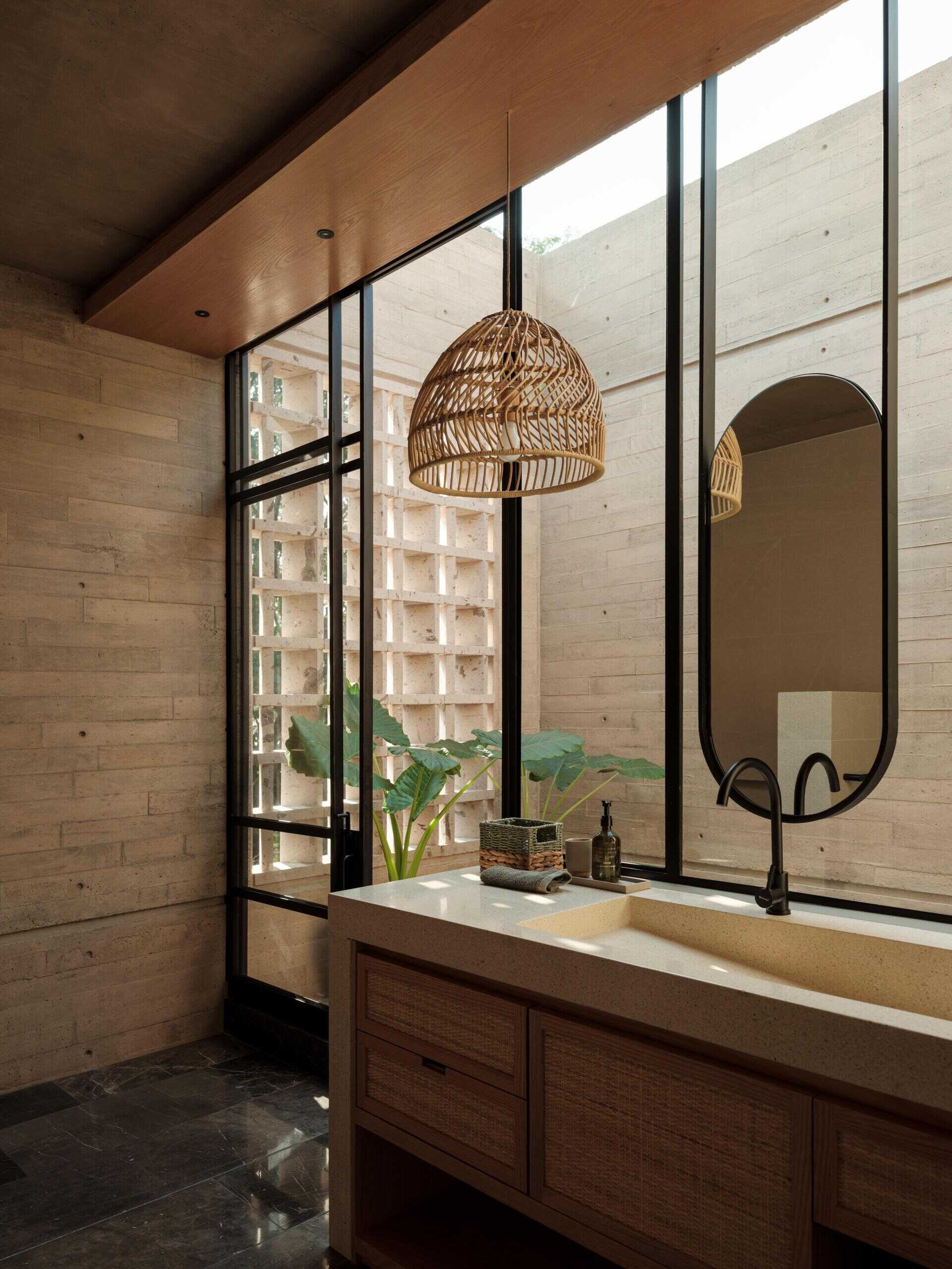 Explore a modern primary bedroom suite featuring a private sitting area, built-in bookshelves, woven sliding doors, a bedroom with geometric breeze-block screens, and a bathroom overlooking a planted courtyard.