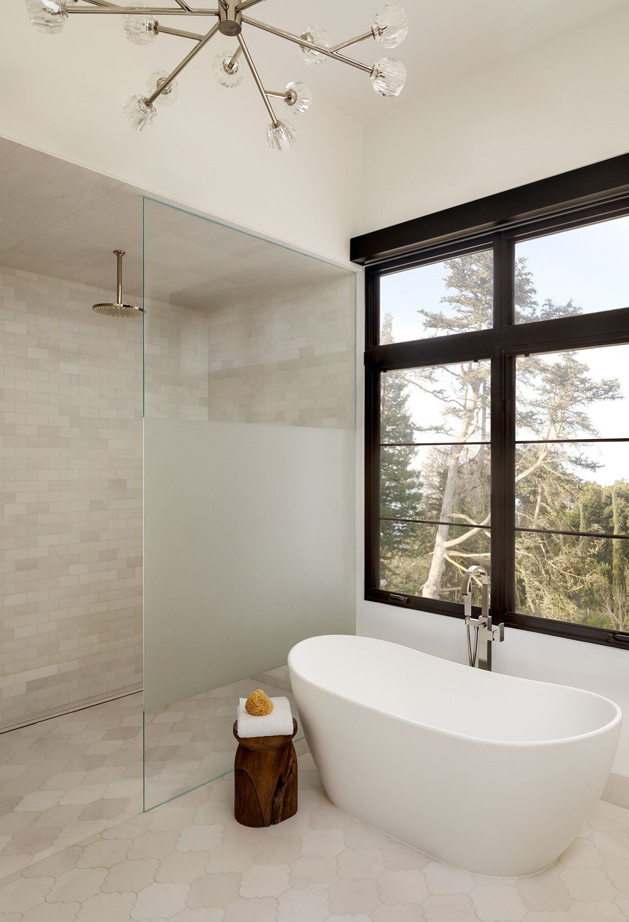 Explore the Atherton Residence bathroom by Paulina Carcach Studio, featuring a freestanding tub, walk-in shower, skylight, grey-veined marble walls and a long matte black double vanity.