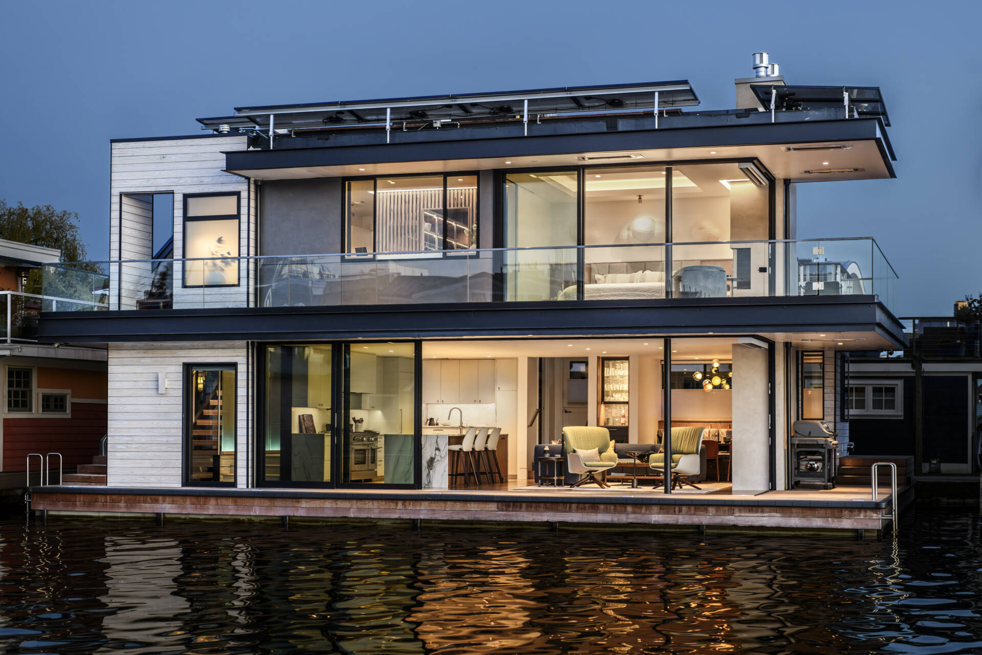 Explore the architecture of Modern Beach House, a two-story floating home on Seattle's Lake Union by Hoshide Wanzer Architects + Interiors. Featuring weathered yakisugi siding, expansive sliding glass doors, glass balconies, and waterfront decks, this contemporary house combines modern architecture with practical floating-home design.