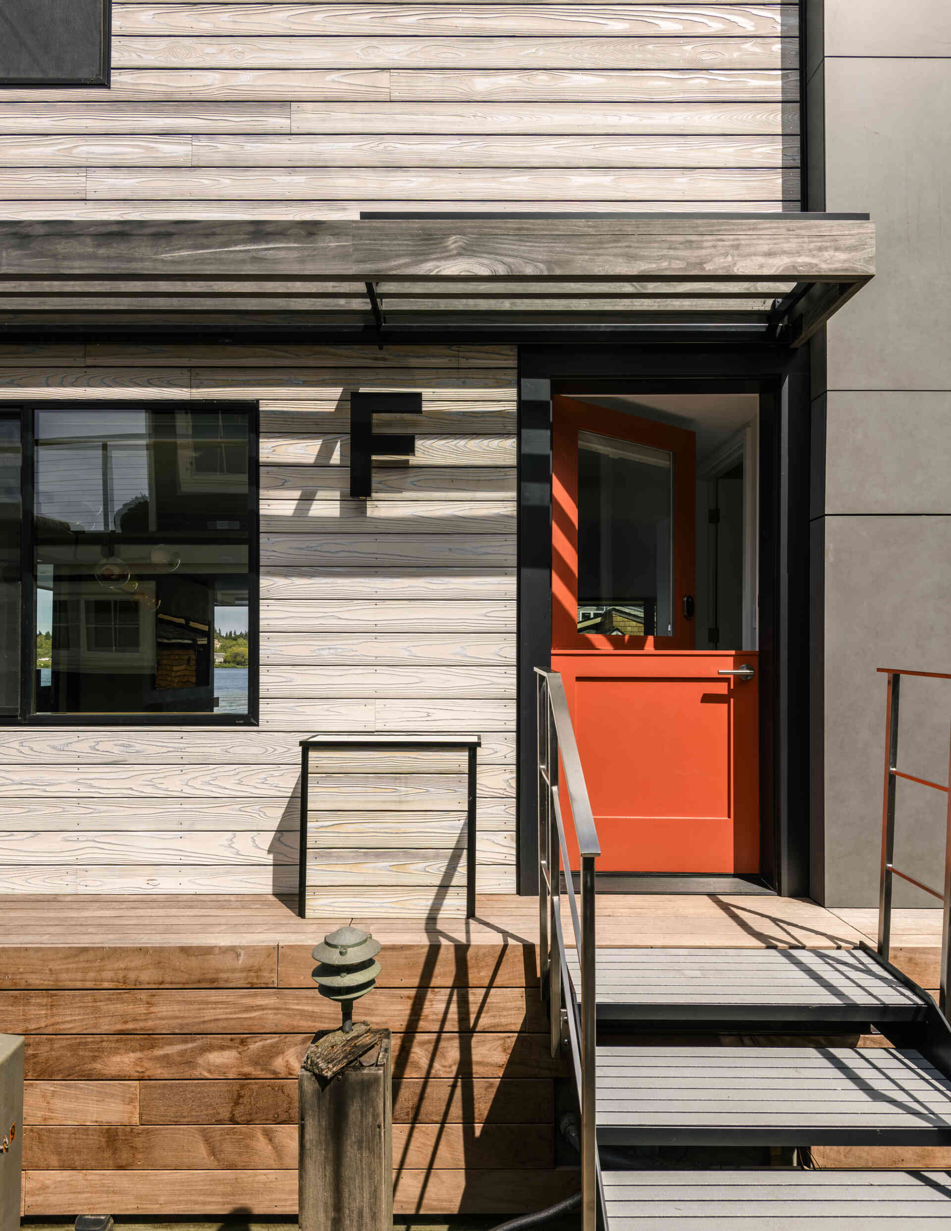 Explore the architecture of Modern Beach House, a two-story floating home on Seattle's Lake Union by Hoshide Wanzer Architects + Interiors. Featuring weathered yakisugi siding, expansive sliding glass doors, glass balconies, and waterfront decks, this contemporary house combines modern architecture with practical floating-home design.