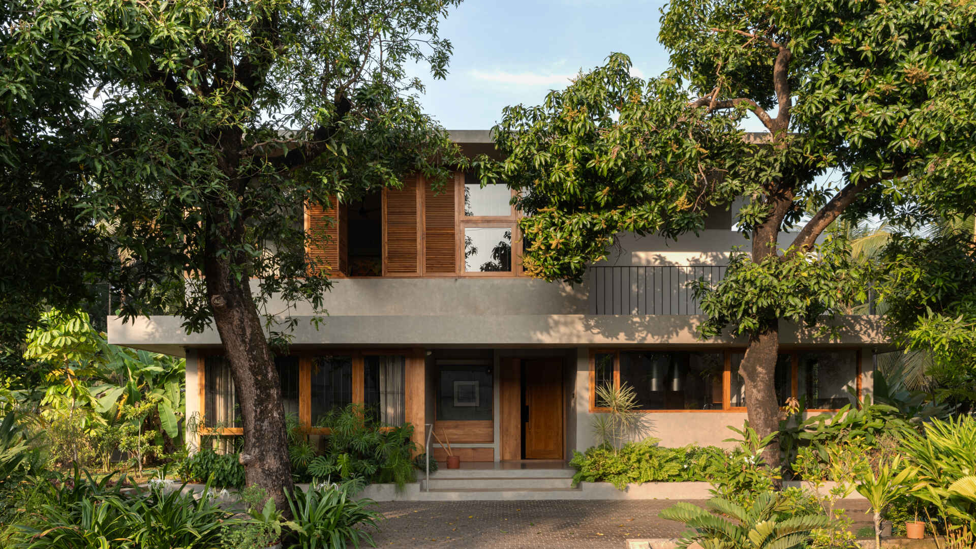 Explore House Beyond the Mango Trees, a contemporary home in Kannur, India, designed by inLe architects around two mature mango trees.