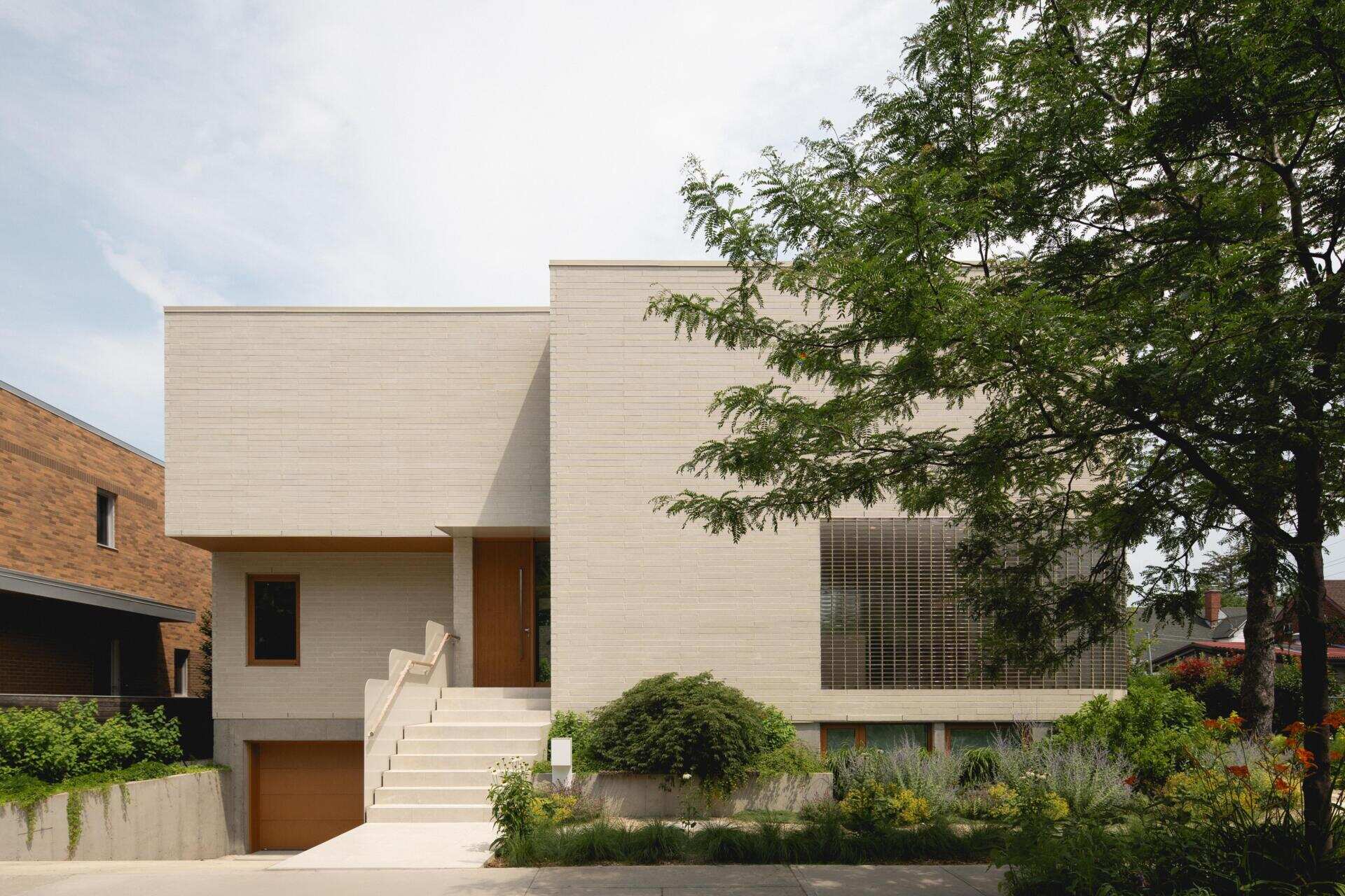 Discover The Lens by MU Architecture, a modern family home in Montreal, Canada, featuring Japanese-inspired minimalism, curved glass brick walls, warm wood interiors, and contemporary architecture.