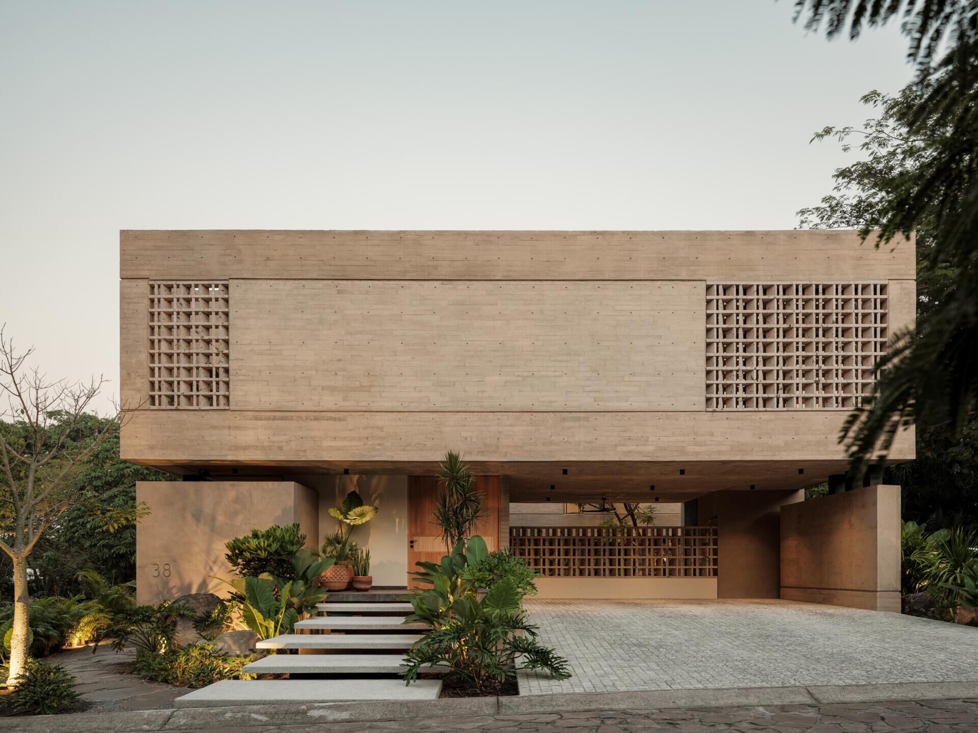 Explore the architecture of Casa Akina in Mexico by Di Frenna arquitectos, featuring board-formed concrete, geometric breeze-block facades, cantilevered volumes, natural stone, and tropical landscaping.