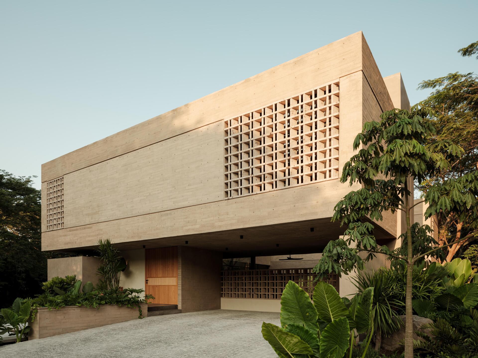 Explore the architecture of Casa Akina in Mexico by Di Frenna arquitectos, featuring board-formed concrete, geometric breeze-block facades, cantilevered volumes, natural stone, and tropical landscaping.